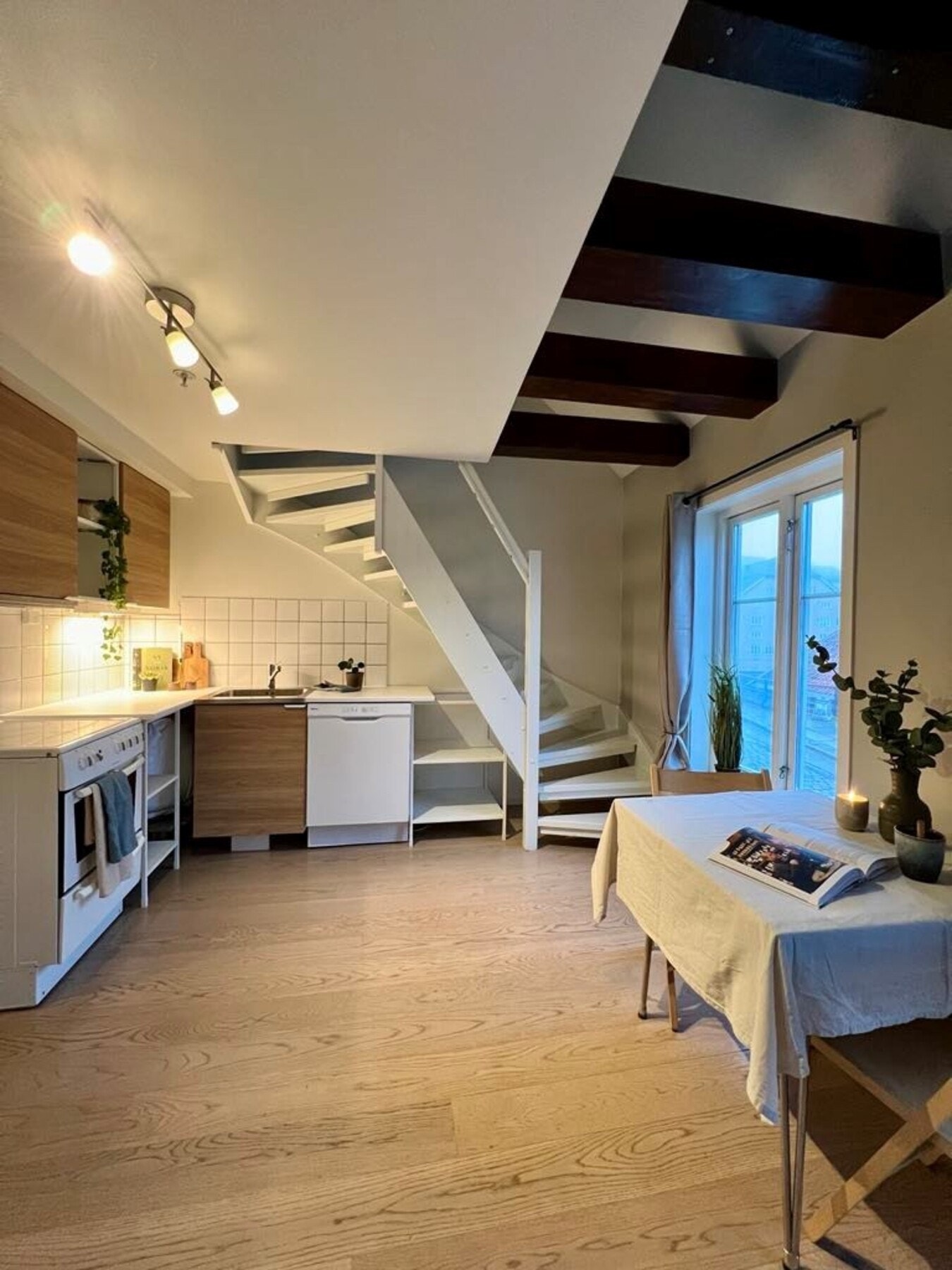 Praktisk kjøkken med god benkeplass, uttak til vaskemaskin, og komfyr med avtrekk over. Galleribilde
