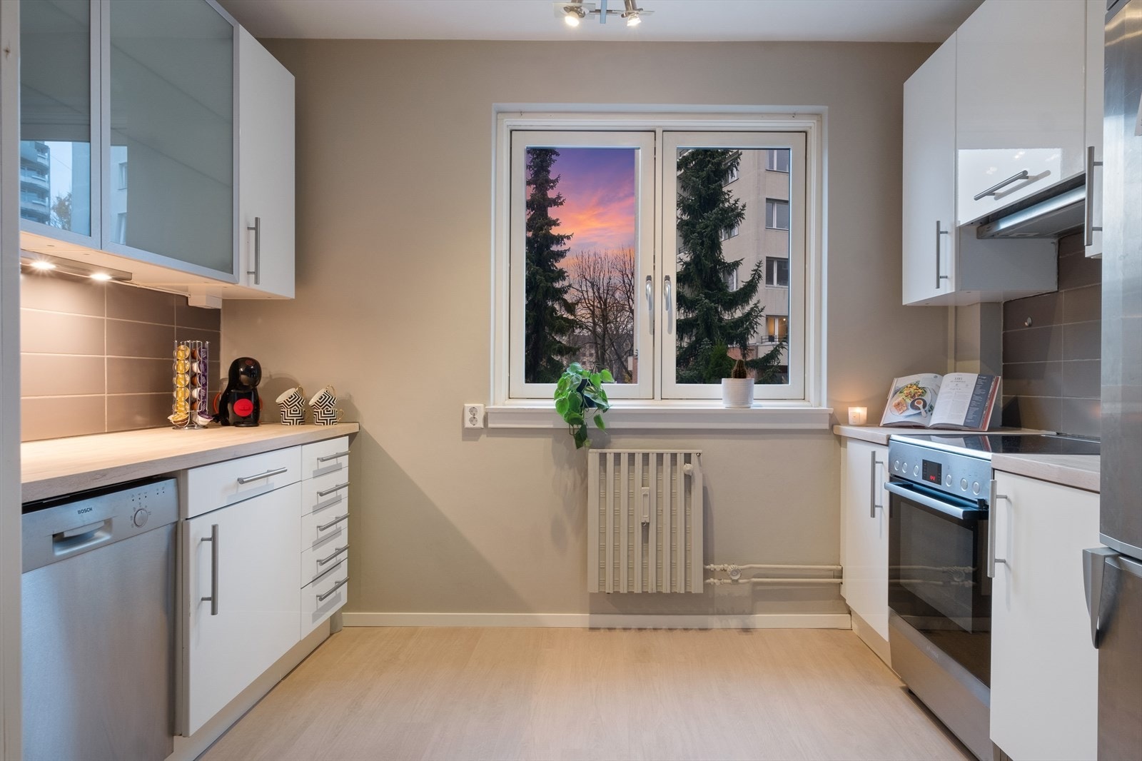 Boligen har et innbydende og tiltalende kjøkken med plass til lite spisebord. Kjøkkenet er designet og innredet med tanke på funksjonalitet, og har godt med skap- og benkeplass som gjør matlagingen til en glede. Galleribilde