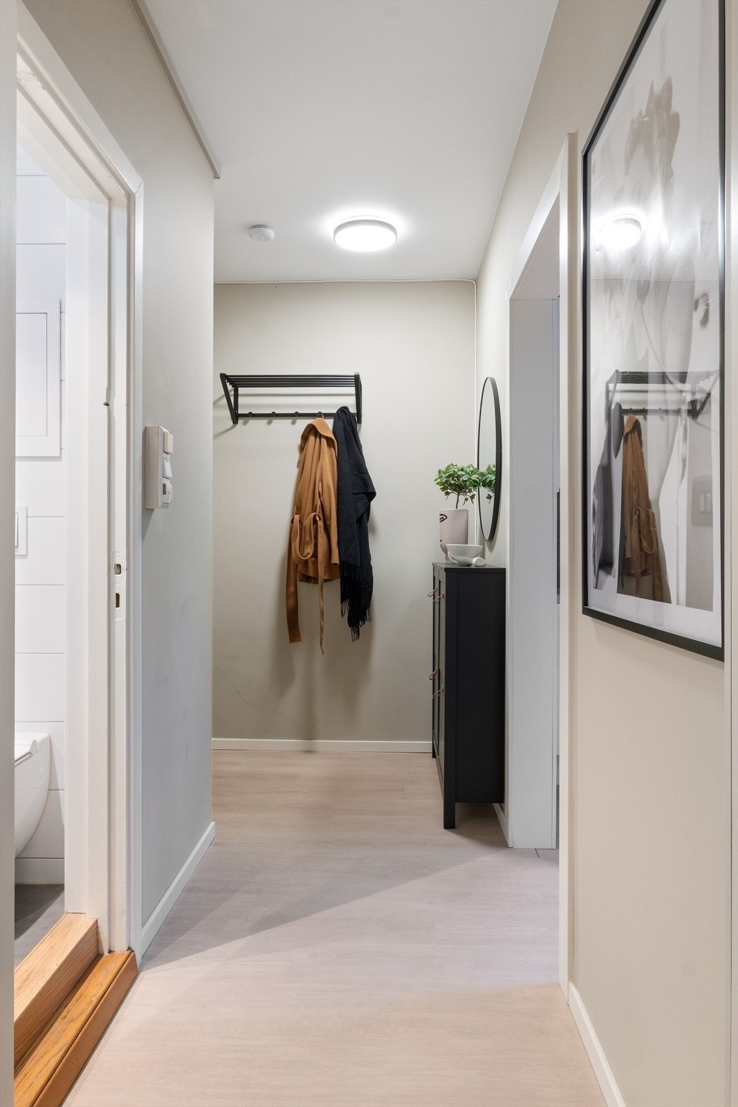 Stilren og moderne gang med 1-stavs BerryAlloc Original Blonde Oak laminatgulv, som gir et godt førsteinntrykk av leiligheten. Her er det godt med plass til klesoppheng og sko. Fra gangen er det videre adkomst til bad, kjøkken, stue og soverom. Galleribilde