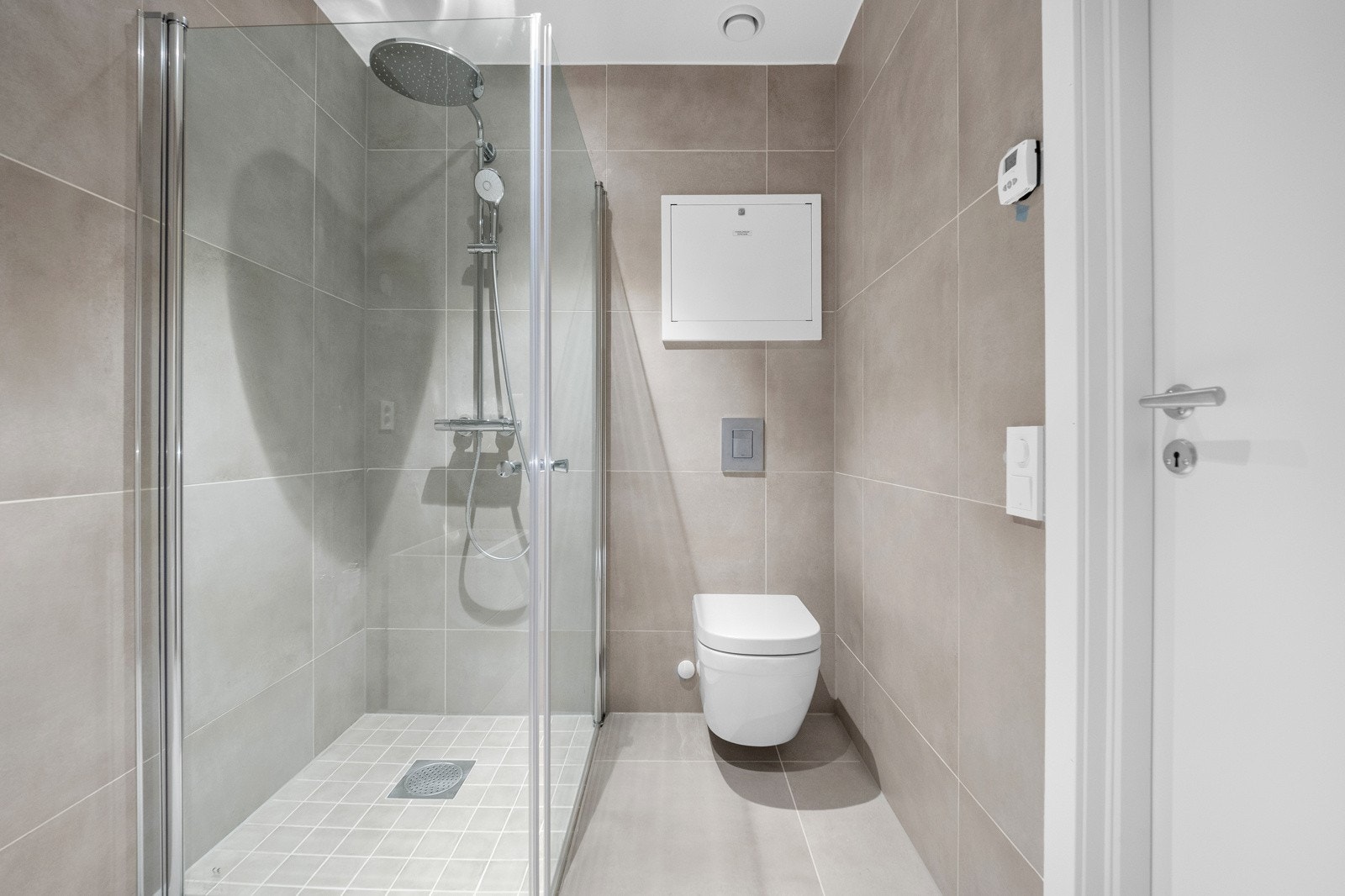 Flott flislagt bad med baderomsinnredning med nedfelt servant, klosett og dusjhjørne Galleribilde