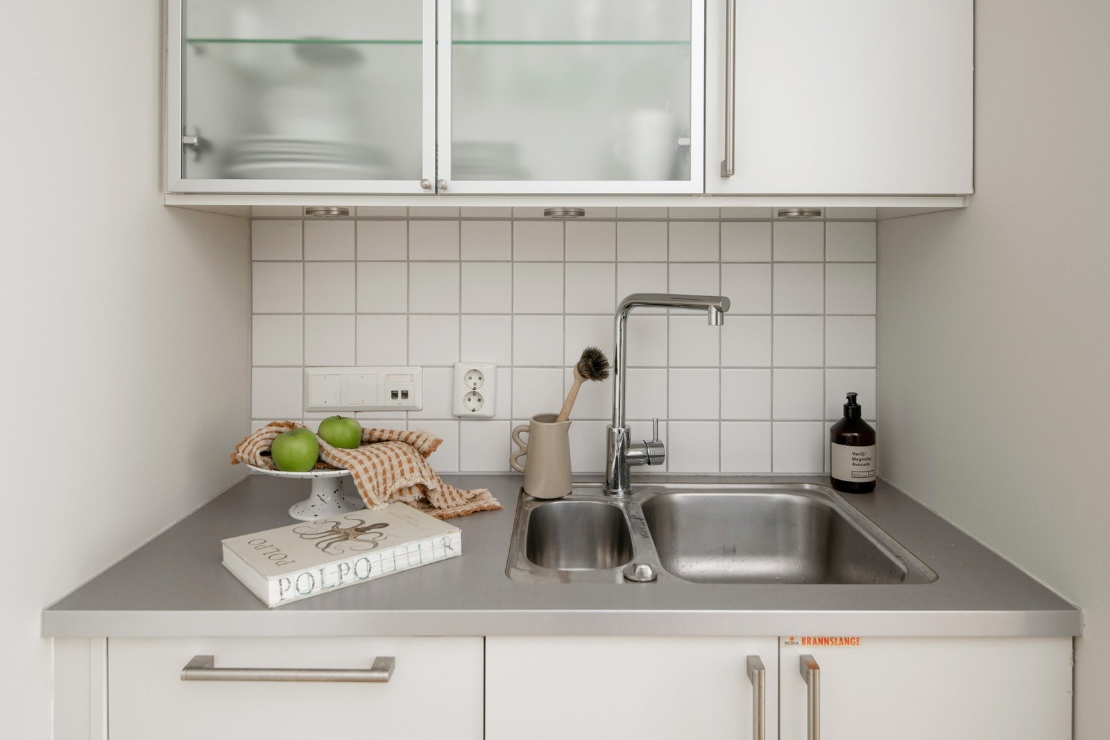 De integrerte hvitevarene som kjøleskap, oppvaskmaskin og stekeovn. Over komfyren er det en nedfelt platetopp. Galleribilde