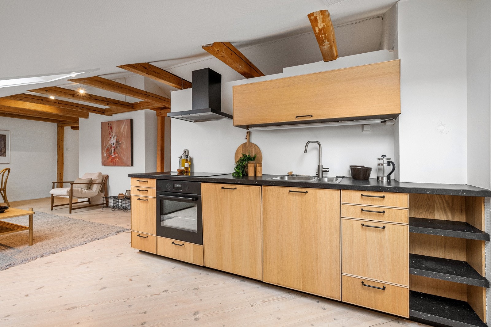 Kjøkkeninnredning med slette fronter og laminat benkeplate med nedfelt vask. Komfyr og oppvaskmaskin er integrert i innredningen Galleribilde