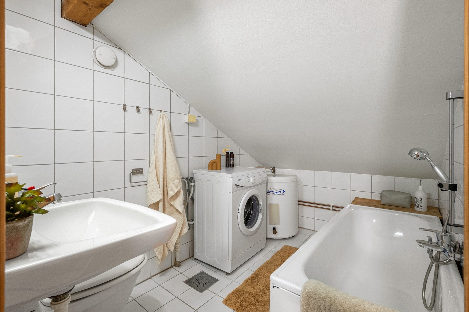 Det ene badet med adkomst fra gang har lyse, flislagte gulv og vegger. Galleribilde