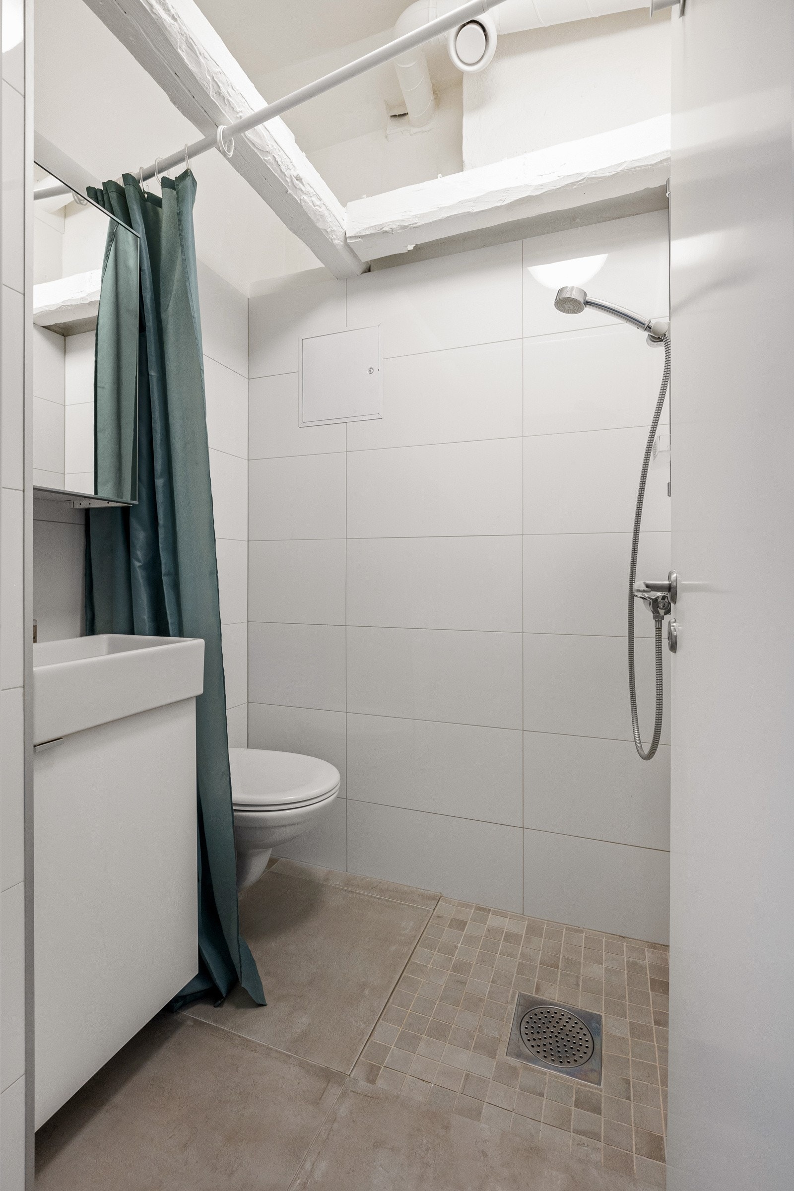 Bad i tilknytning til den ene soverommet. Badet er utstyrt med servantinnredning, enkelservant med ettgreps armatur, dusj med forheng, speil og vegghengt toalett. Galleribilde