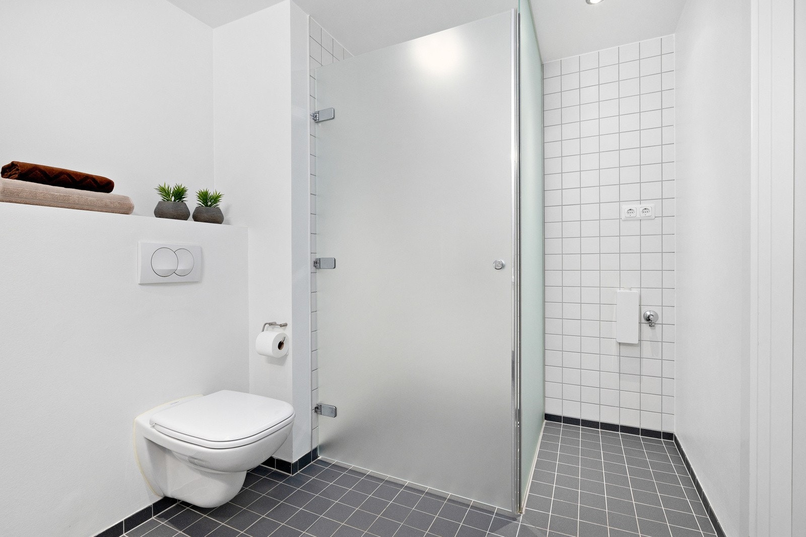 På badet er det downlights, vegghengt toalett og et dusjhjørne med svingbar glassdør. Galleribilde