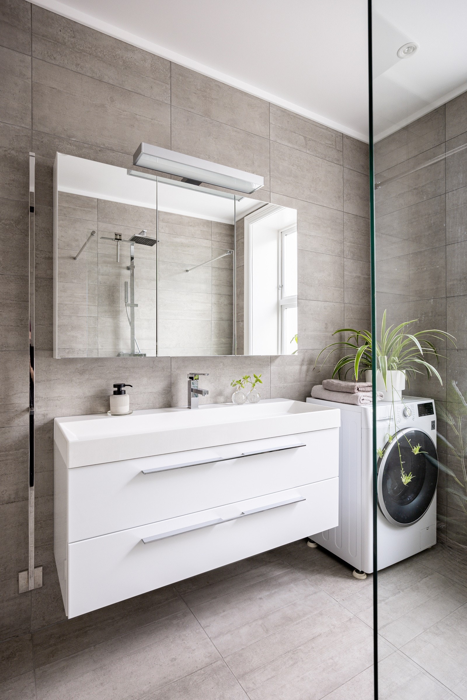 Badet har moderne innredning med speilskap med lyssensor, servantskap med oppbevaring og opplegg for vaskemaskin/tørketrommel. Det er varmekabler på gulvet. Galleribilde