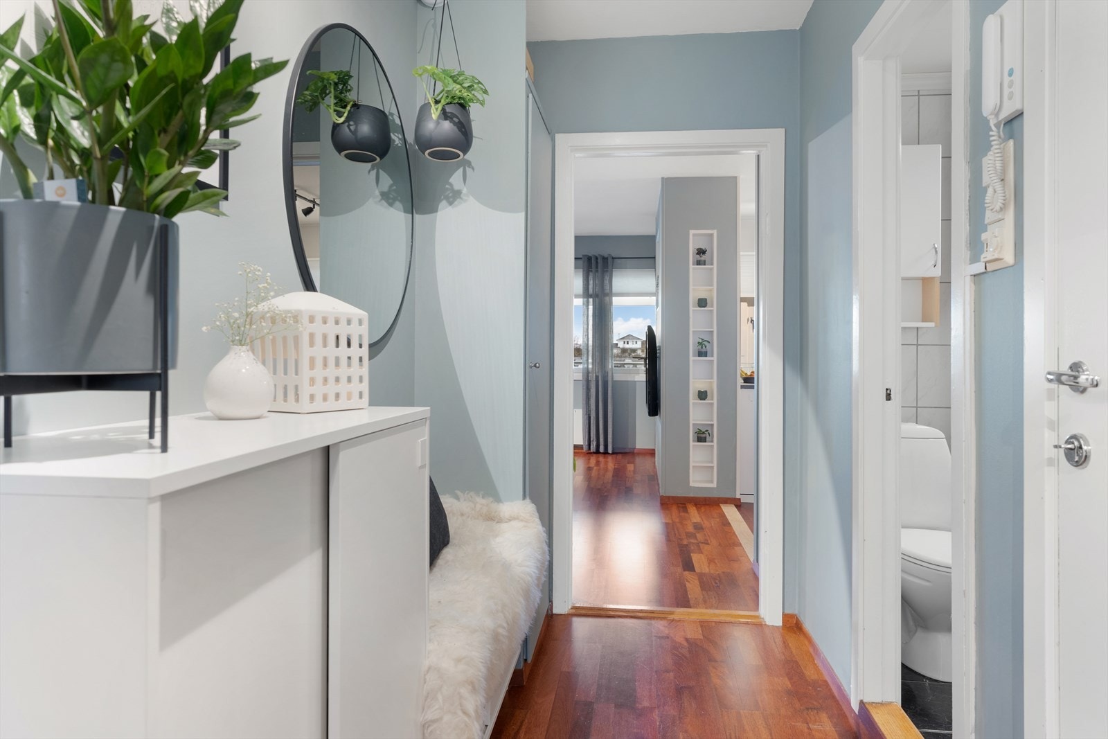 Romslig og innbydende entré/gang med garderobeskap og skyvedørsgarderobe med speildører Galleribilde