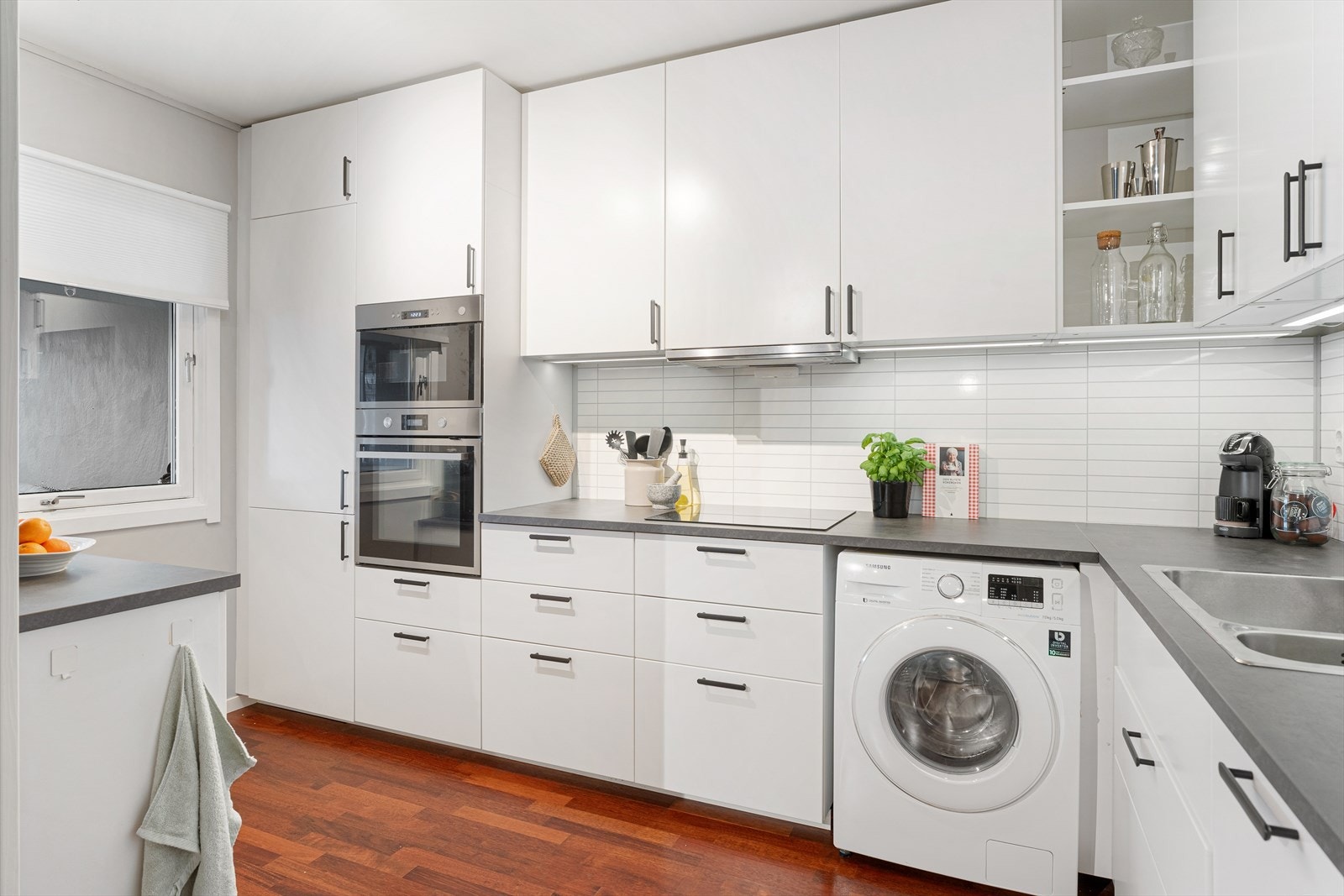 Pent, oppusset kjøkken med hvite slette fronter. Galleribilde