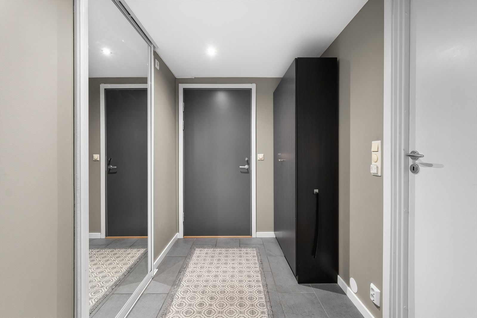 Romslig entré med god plass til garderobeskap. Inngang til bad og walk-in-closet. Galleribilde