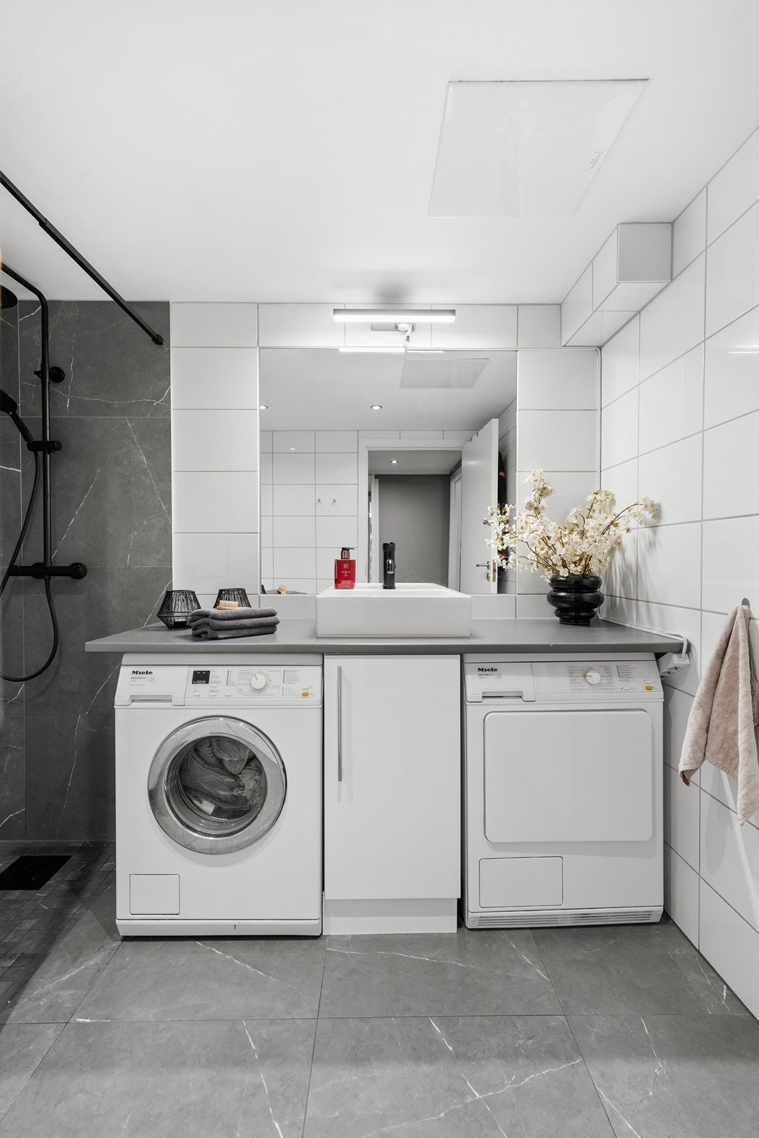 Badet har plass til vaskemaskin og tørketrommel. Den ene kan enkelt byttes ut for enda mer skapplass. Galleribilde