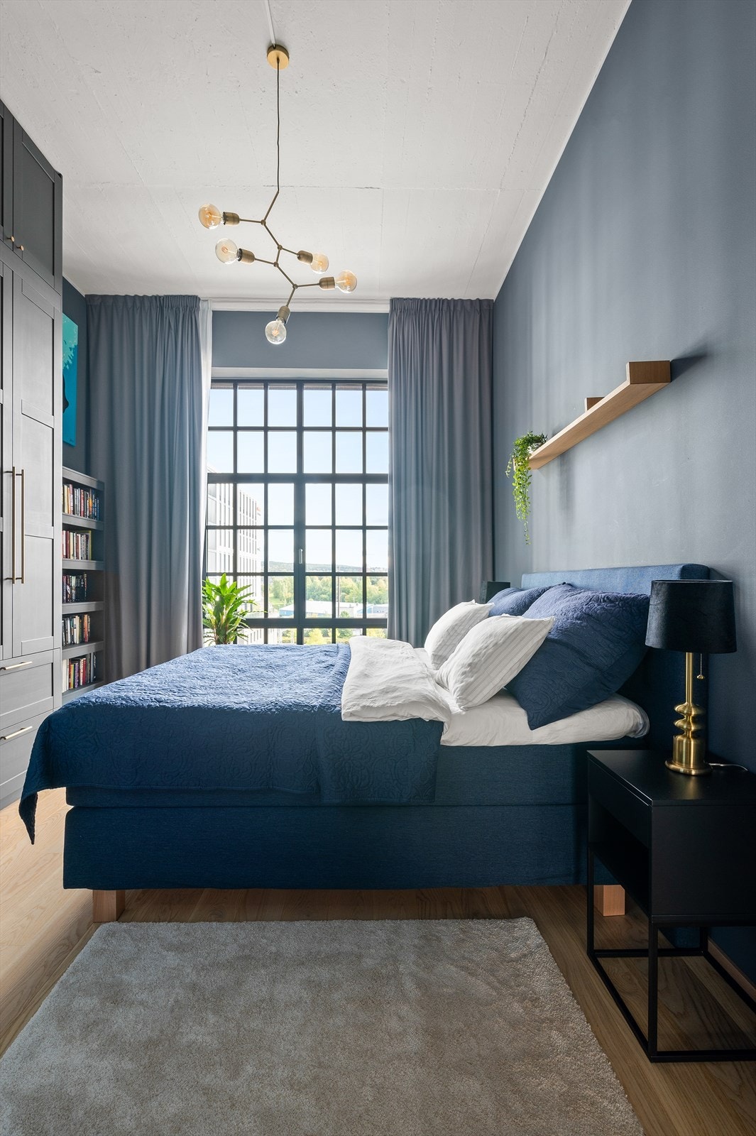 Boligens første soverom er av god størrelse med plass til dobbeltseng og tilhørende nattbord Galleribilde