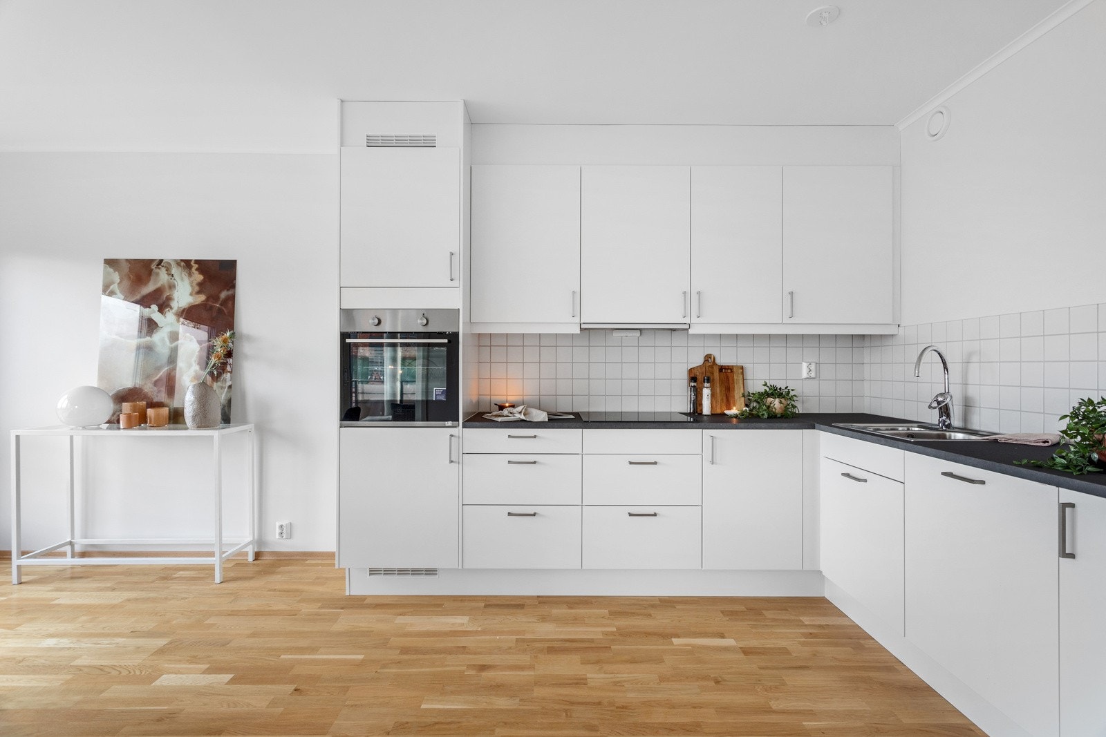 Kjøkken med innredning fra Sigdal, utstyrt med integrerte hvitevarer som kjøleskap, komfyr, platetopp og oppvaskmaskin. Galleribilde