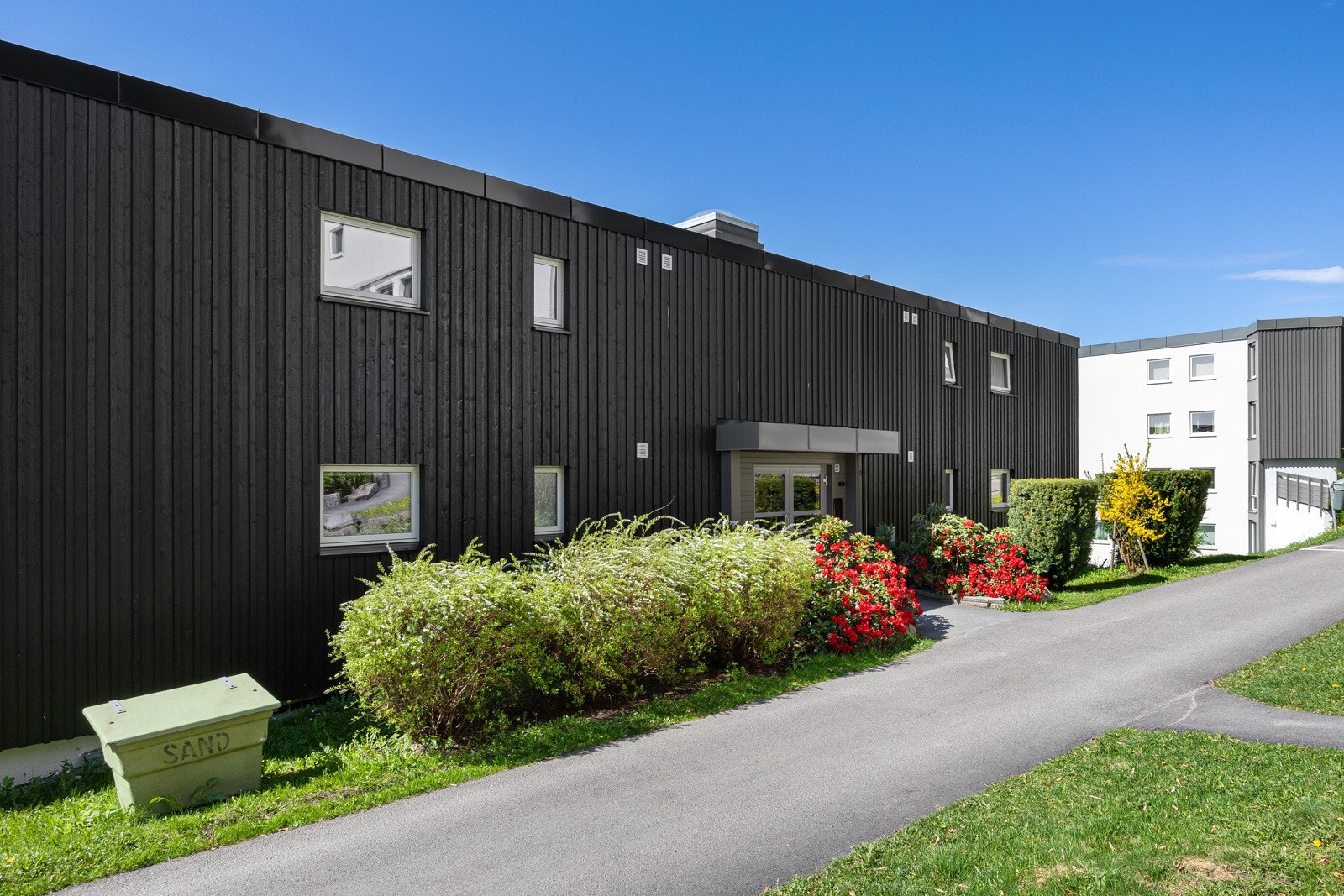 Hyggelig inngangsparti med nyere calling anlegg. I tillegg to fellesboder for sykler/barnevogn rett innenfor hoveddøren til blokka på bakkenivå. Galleribilde