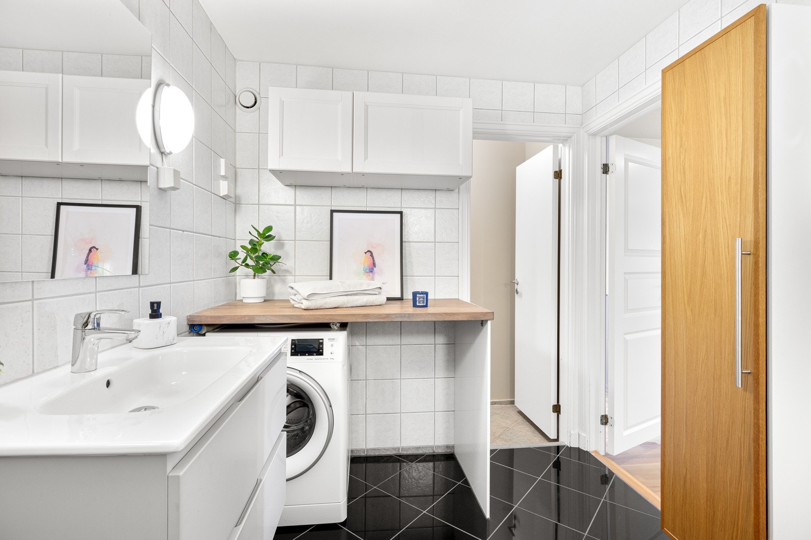 Ved en egen vaskesone er det overskap, benk og opplegg for vaskemaskin. Galleribilde