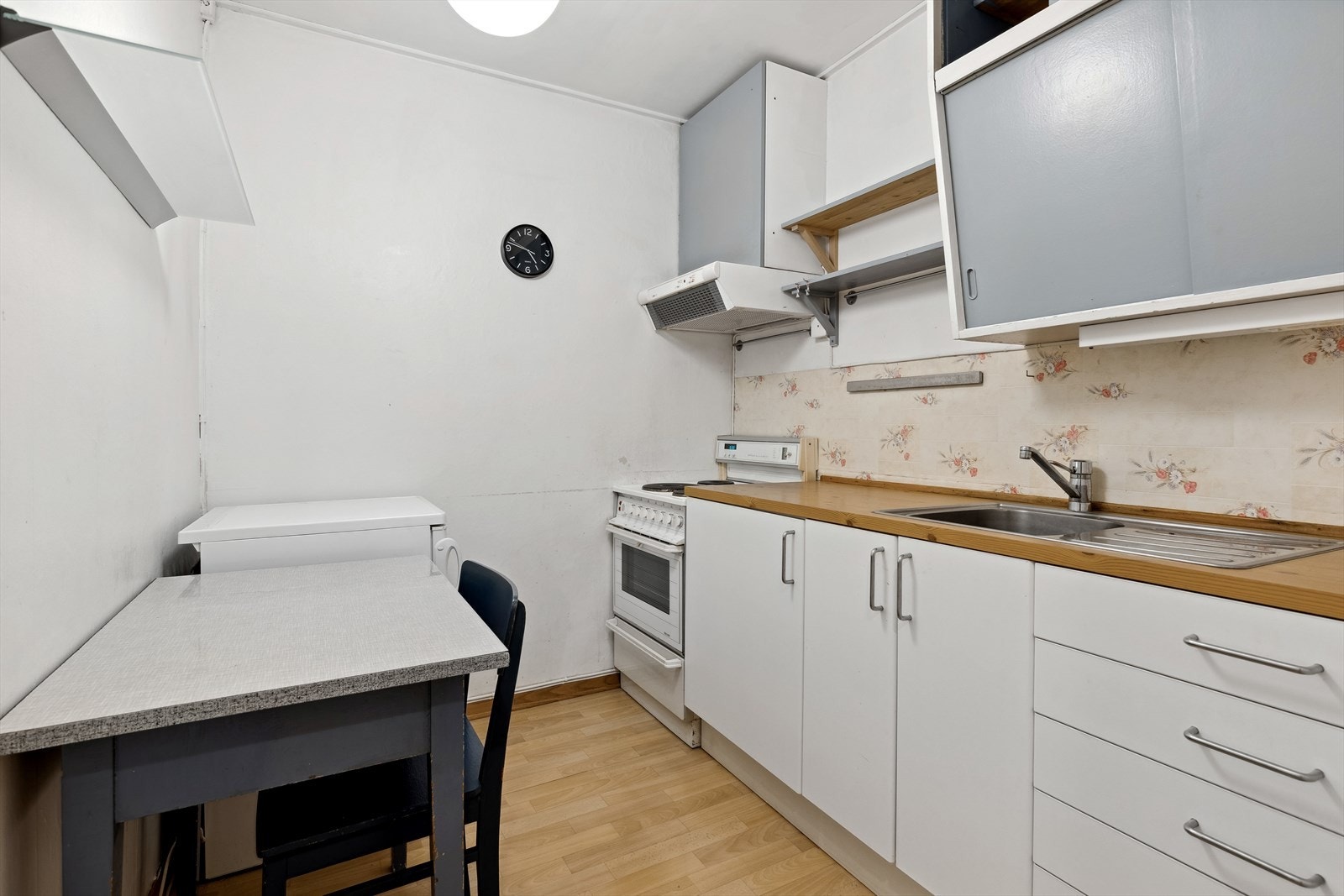 Kjøkkenet i underetasjen har vinylbelegg på gulv, malte vegger og himling. Malt, eldre kjøkkeninnredning med laminat benkeplate. Galleribilde