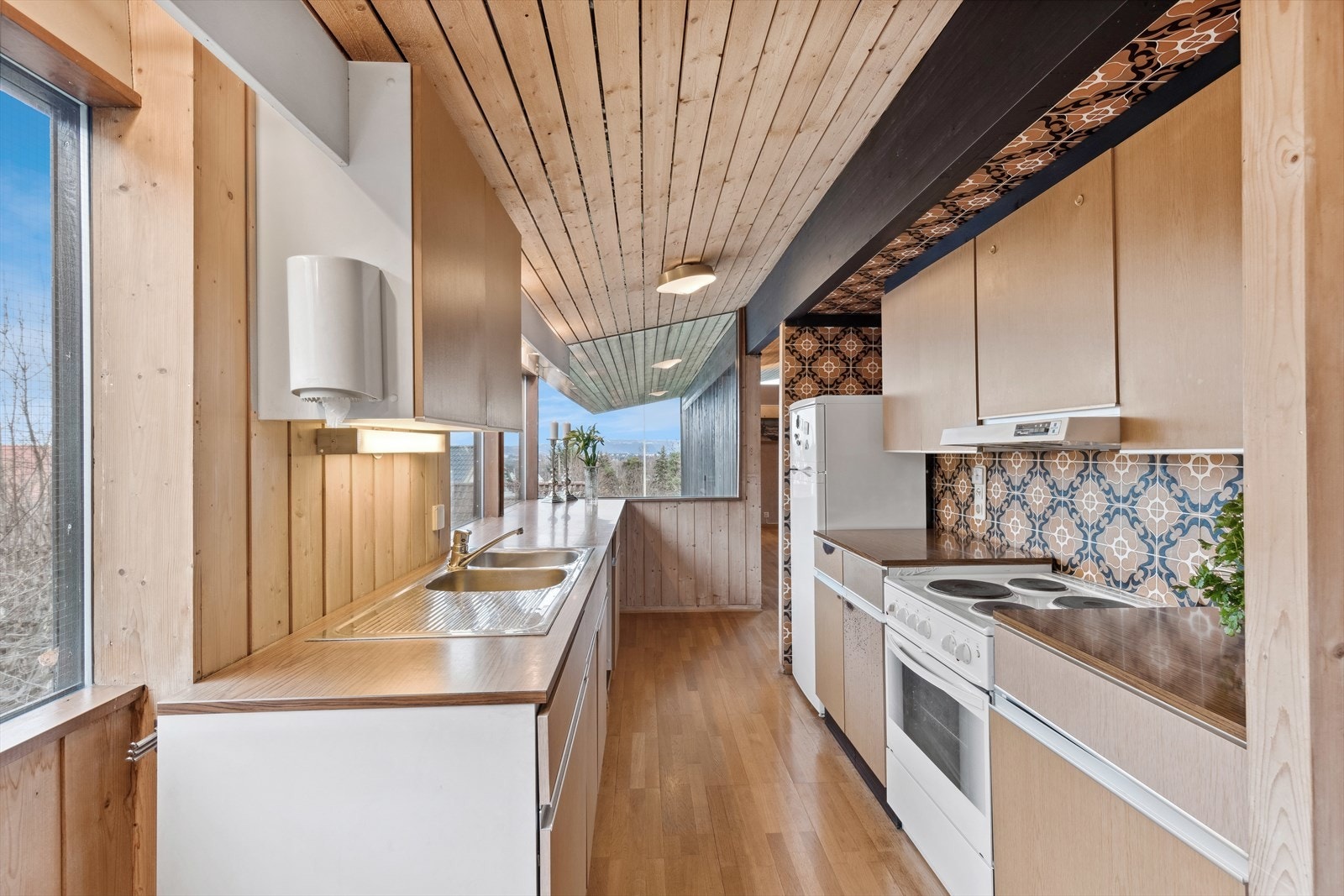 Kjøkkeninnredning med glatte fronter og laminat benkeplate. Galleribilde