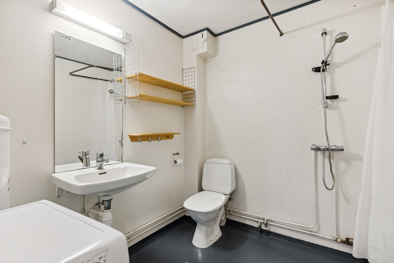 Bad/wc i underetasje har malt betonggulv, malte vegger og himling. Innredet med wc, servant og dusj. Opplegg for vaskemaskin. Våtrommet må oppgraderes/renoveres for å tåle normal bruk etter dagens krav. Galleribilde