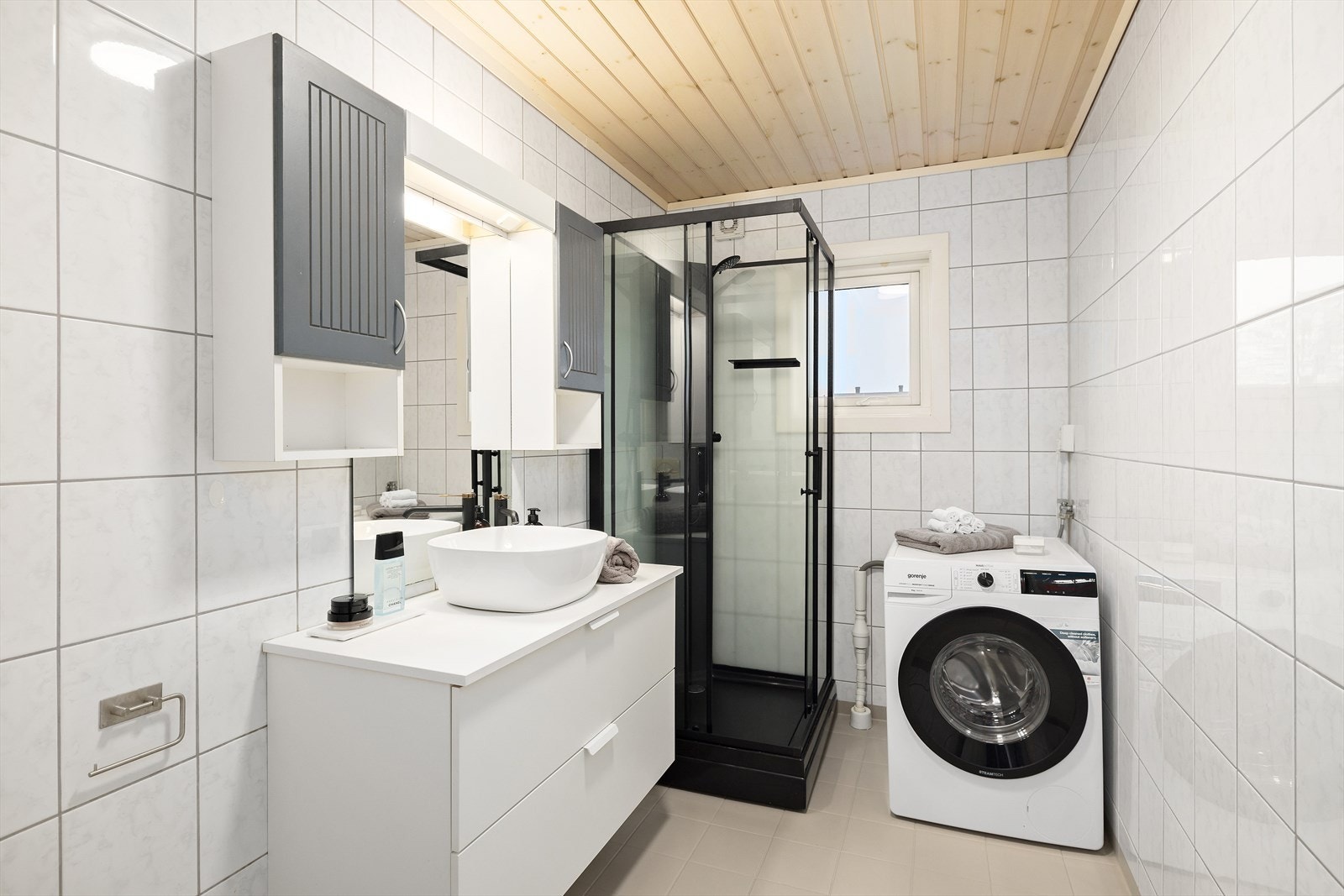 Badet er utstyrt med varmekabler, servant over skuffeinnredning, speil og belysning,. vegghengt skap, toalett, dusjkabinett (2024) og vaskemaskin Galleribilde