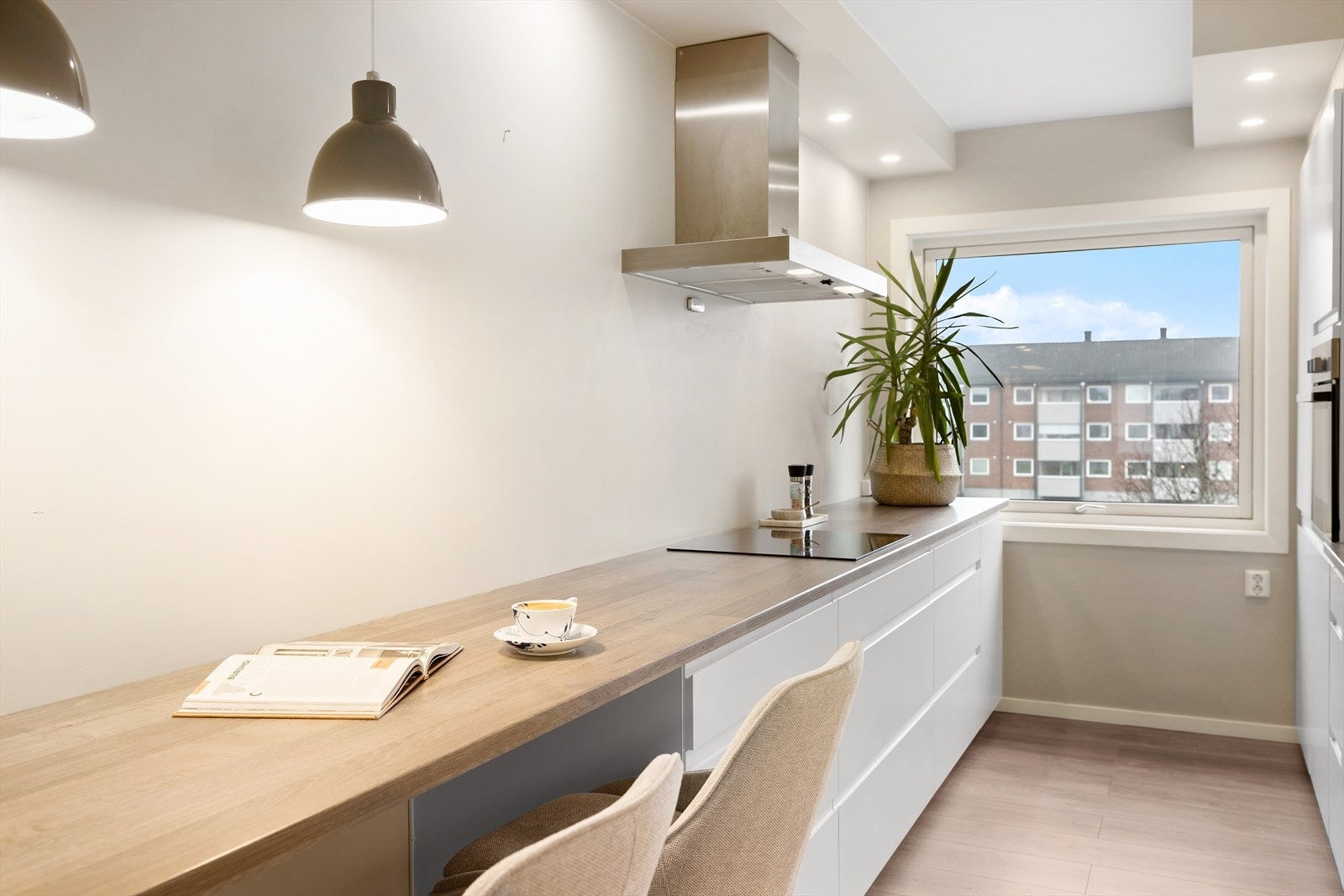 Innredningen har hvite, slette fronter og laminat benkeplate Galleribilde