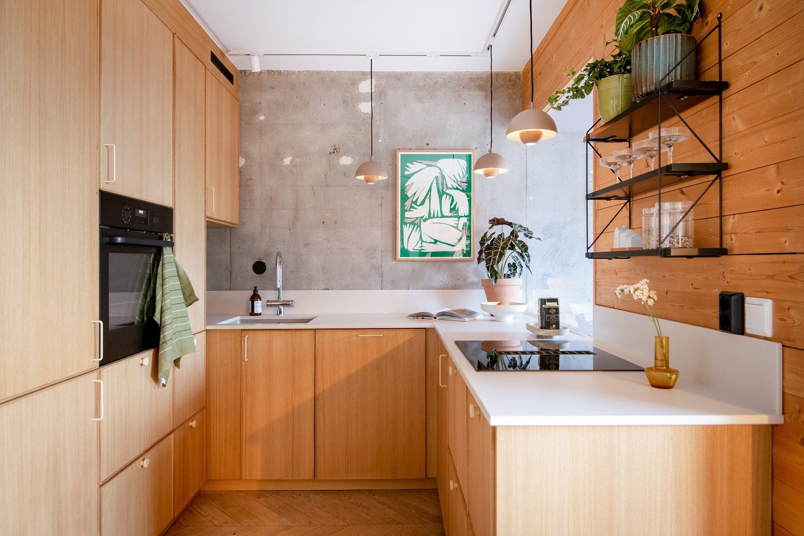 Den åpne løsningen mot et stilfullt kjøkken skaper en harmonisk flyt mellom rommene og legger til rette for sosialt samvær. Galleribilde