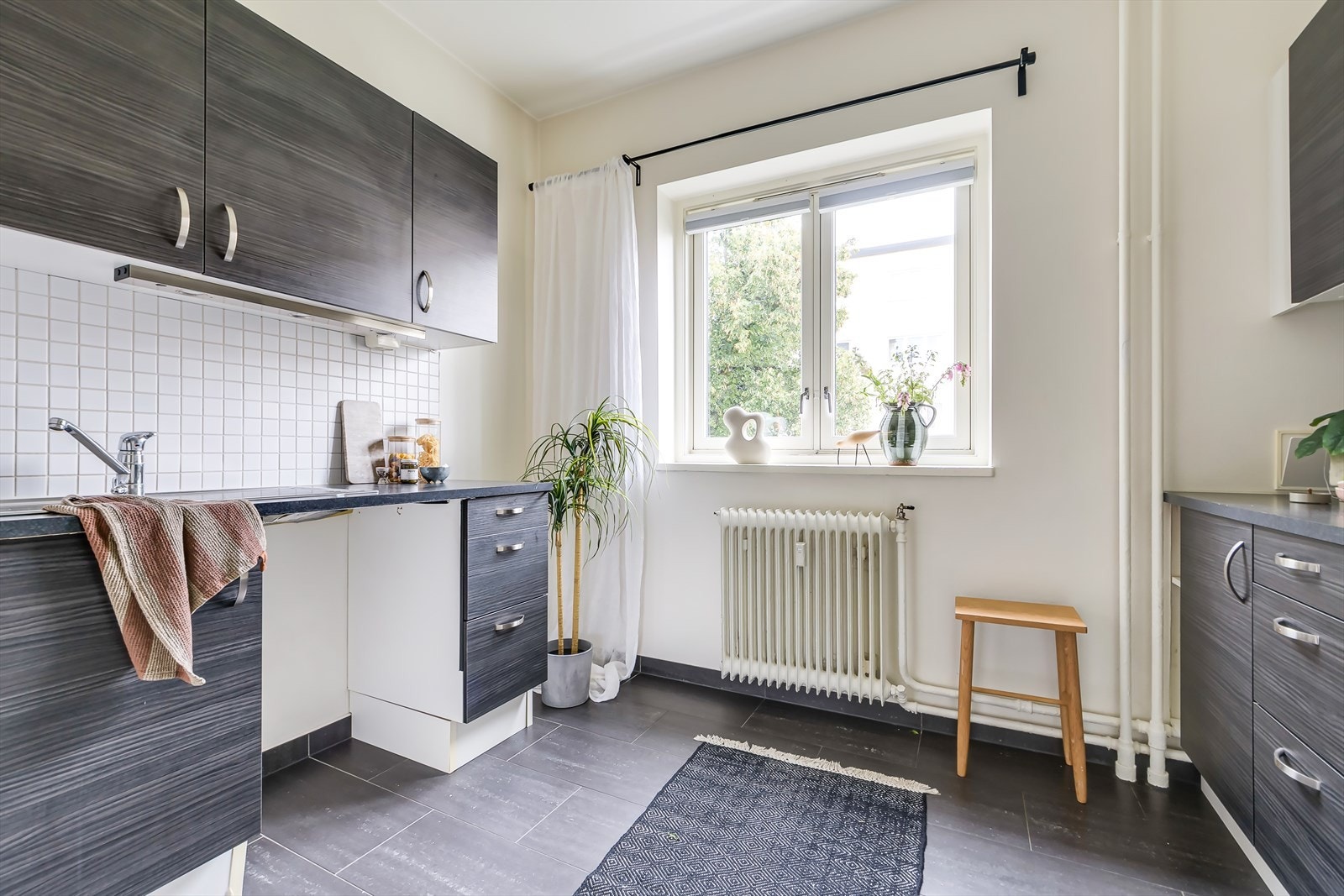 Kjøkkeninnredning består av glatte fronter og benkeplate av laminat med stålkum. Galleribilde