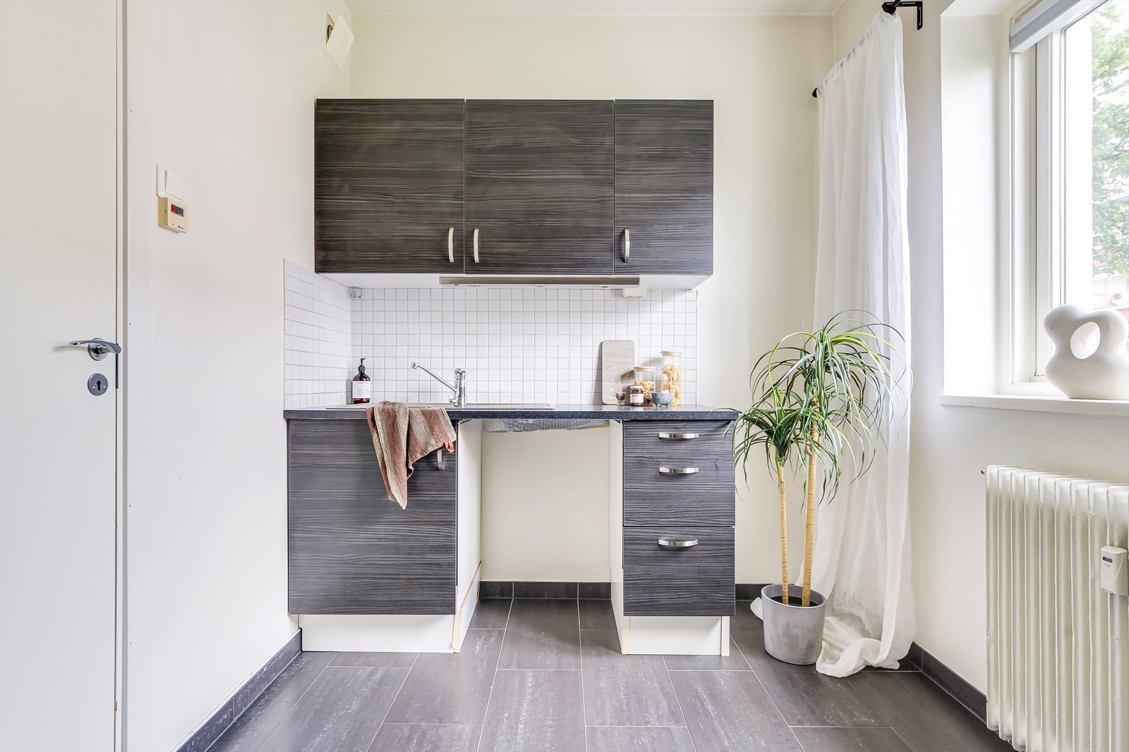 Kjøkkenet ligger adskilt fra stuen med praktisk utforming Galleribilde