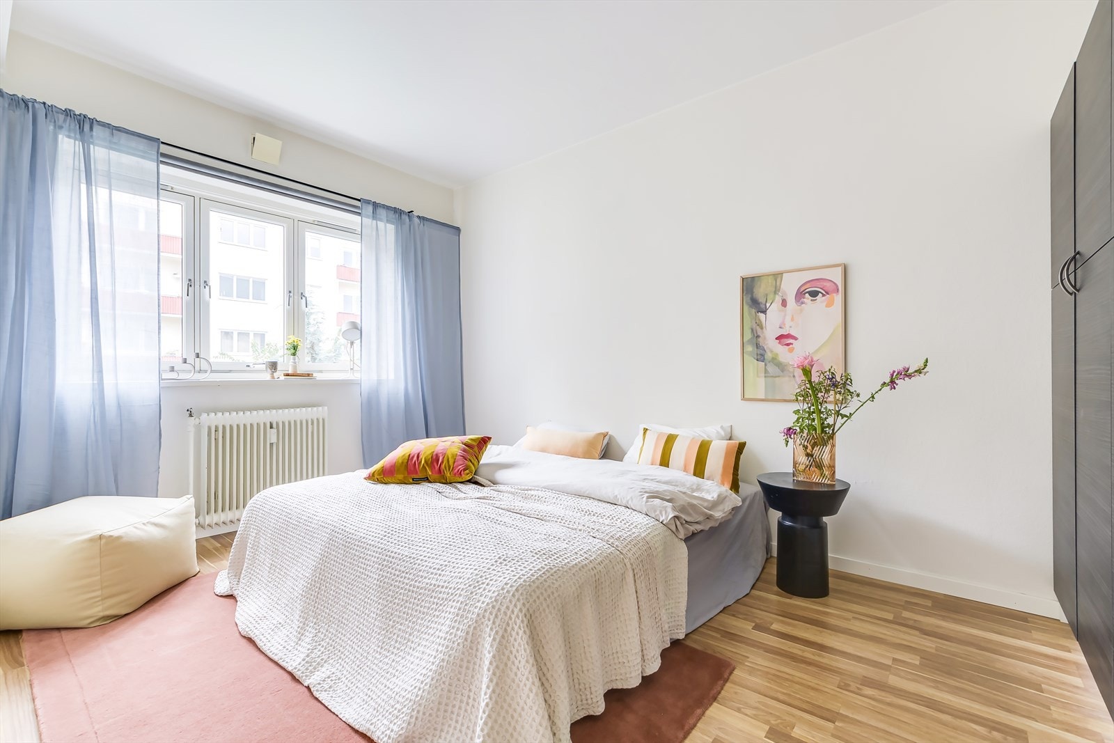 Romslig og innbydende soverom med lysmalte vegger og store vindusflater Galleribilde