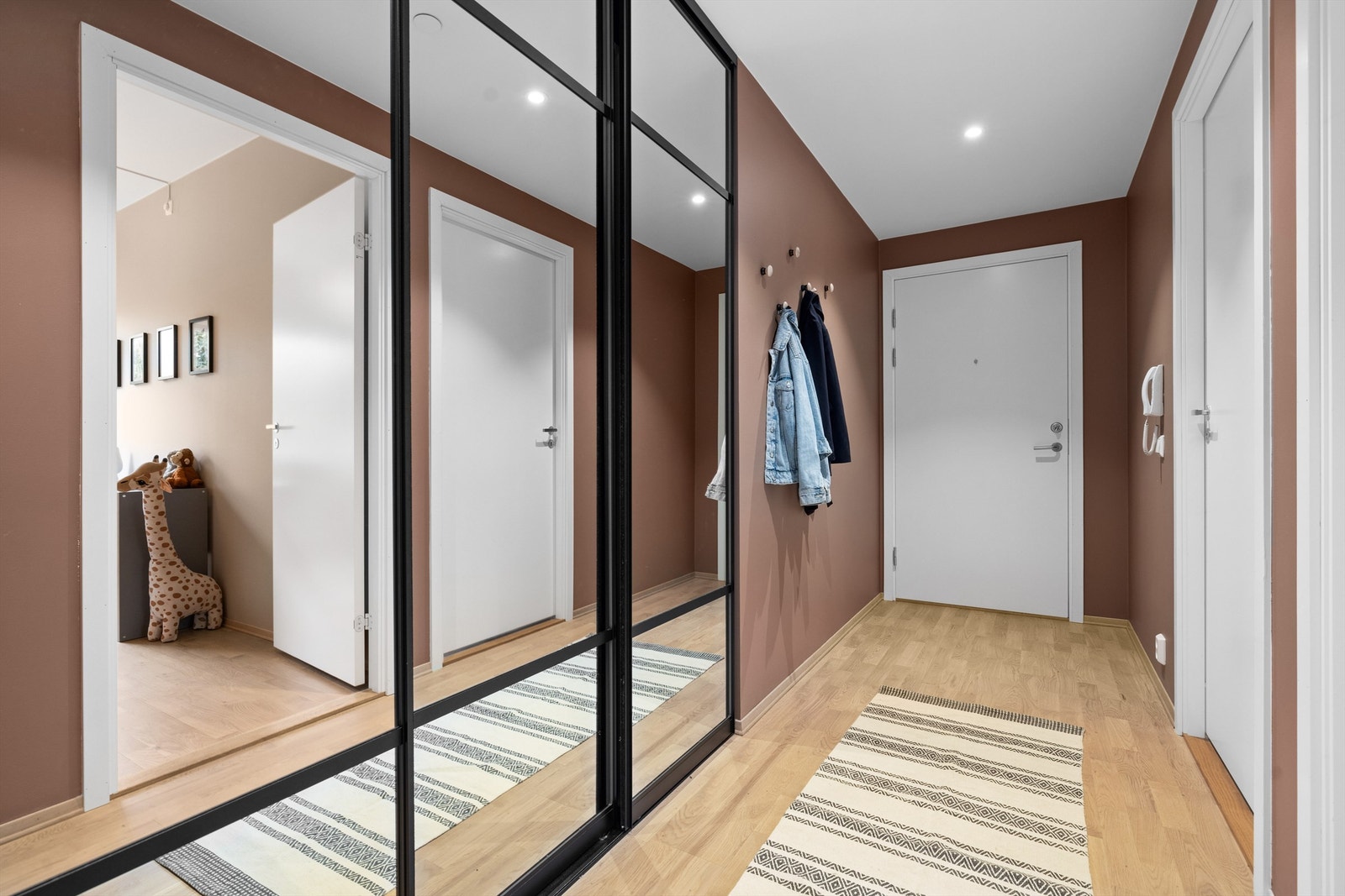 Velkommen inn i en romslig entré med rikelig oppbevaringsplass i innebygd skyvedørsgarderobe Galleribilde