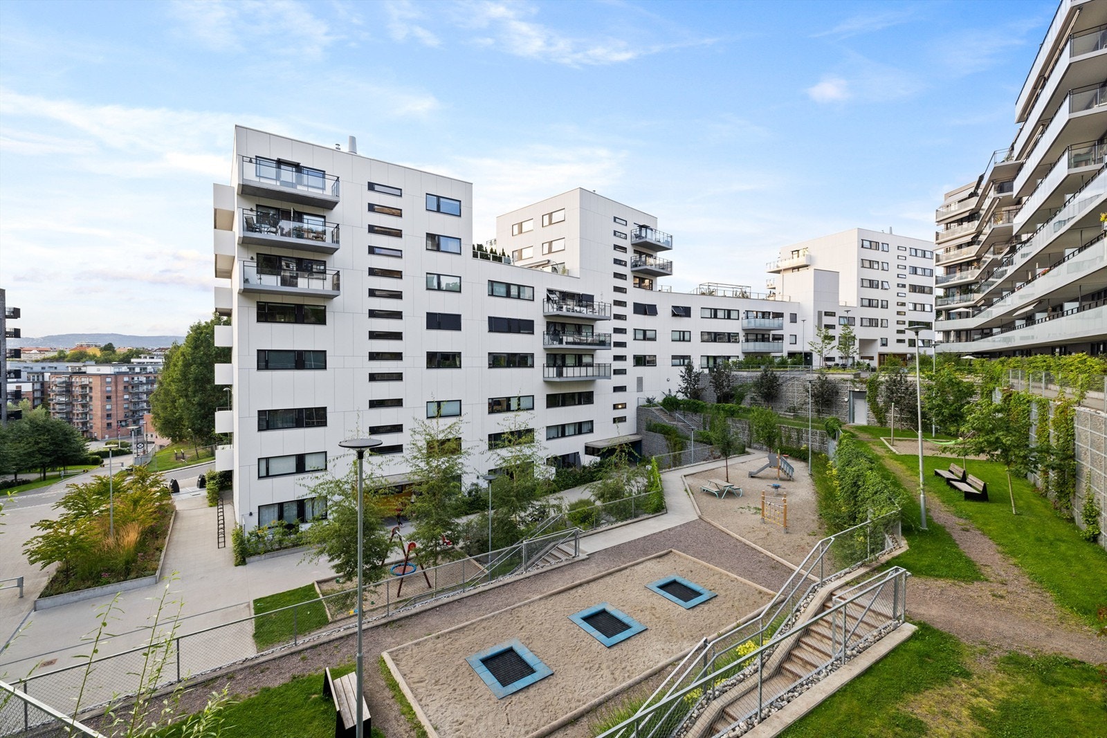 Uteområder er pent opparbeidet med bl.a lekeplass, sykkelparkering, div. støttemurer, trapper, etc. i naturstein, pene hellelagte områder foran bygget og beplantede arealer Galleribilde