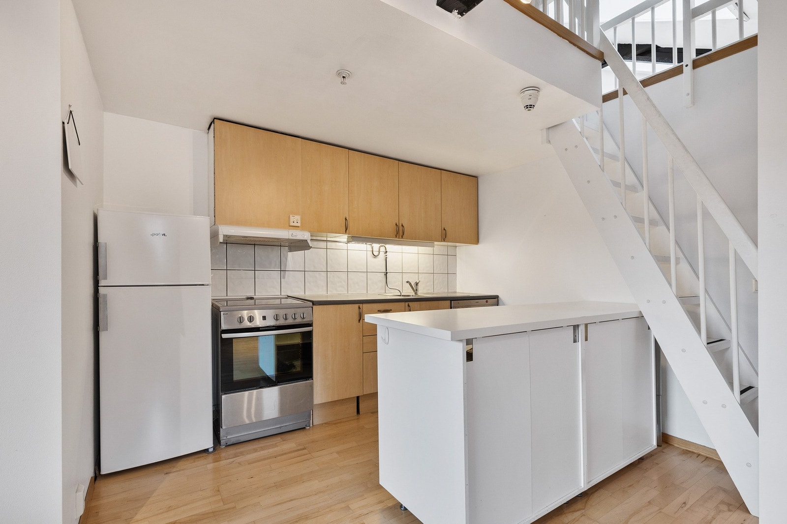 Kjøkkeninnredning med slette fronter og benkeplate med vaskekum og ett-greps armatur Galleribilde