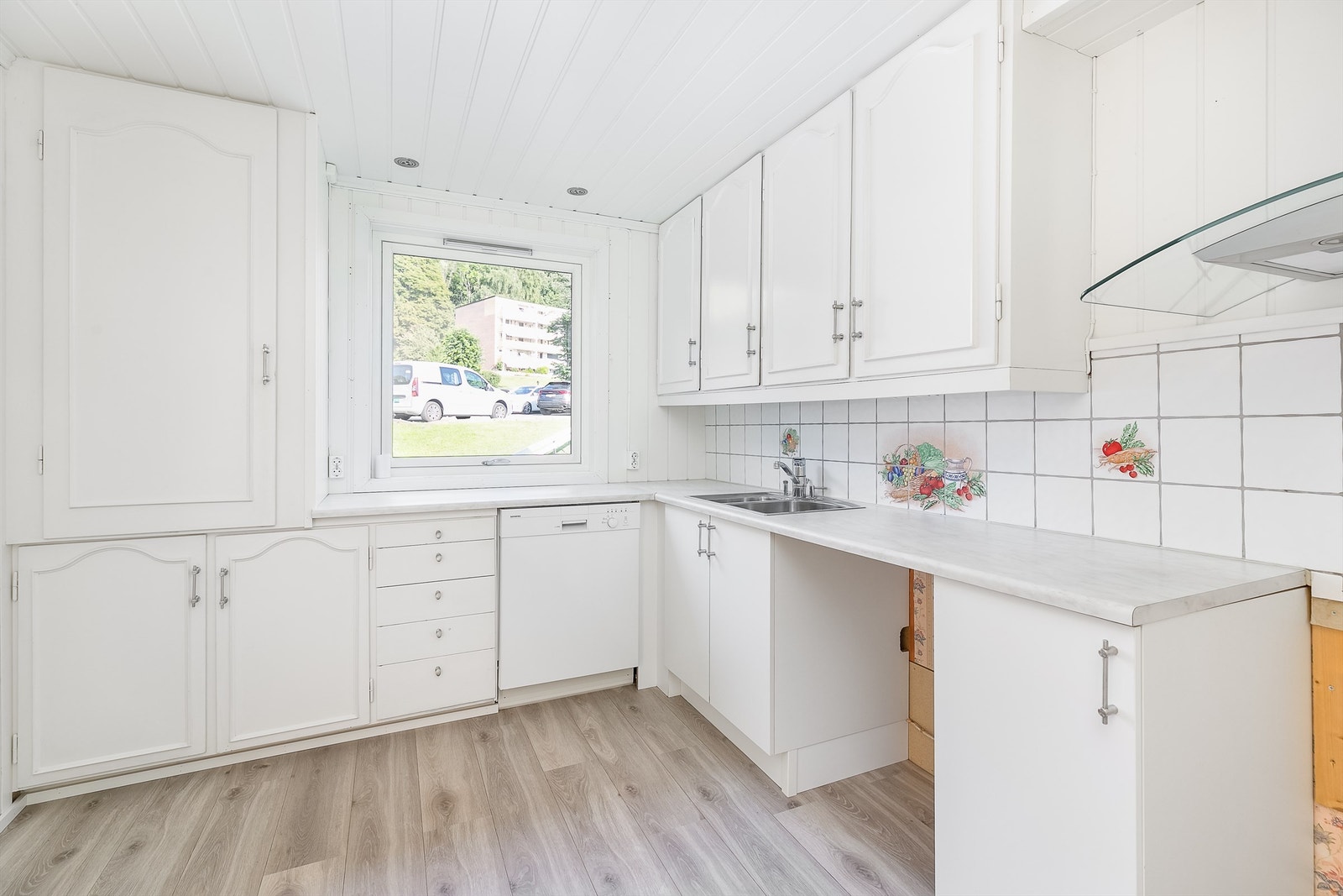 Kjøkkenets skap- og benkeinnredning er dels fra byggeåret, men funksjonell og velholdt i forhold til alder. Galleribilde