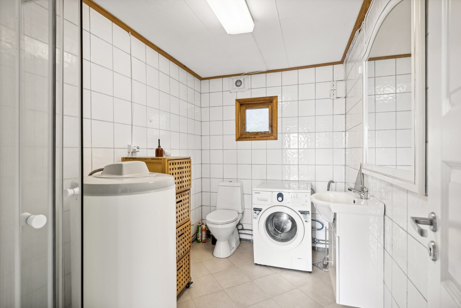 Rommet er innredet med dusjkabinett, toalett, opplegg for vaskemaskin, servantskap og bereder. Galleribilde