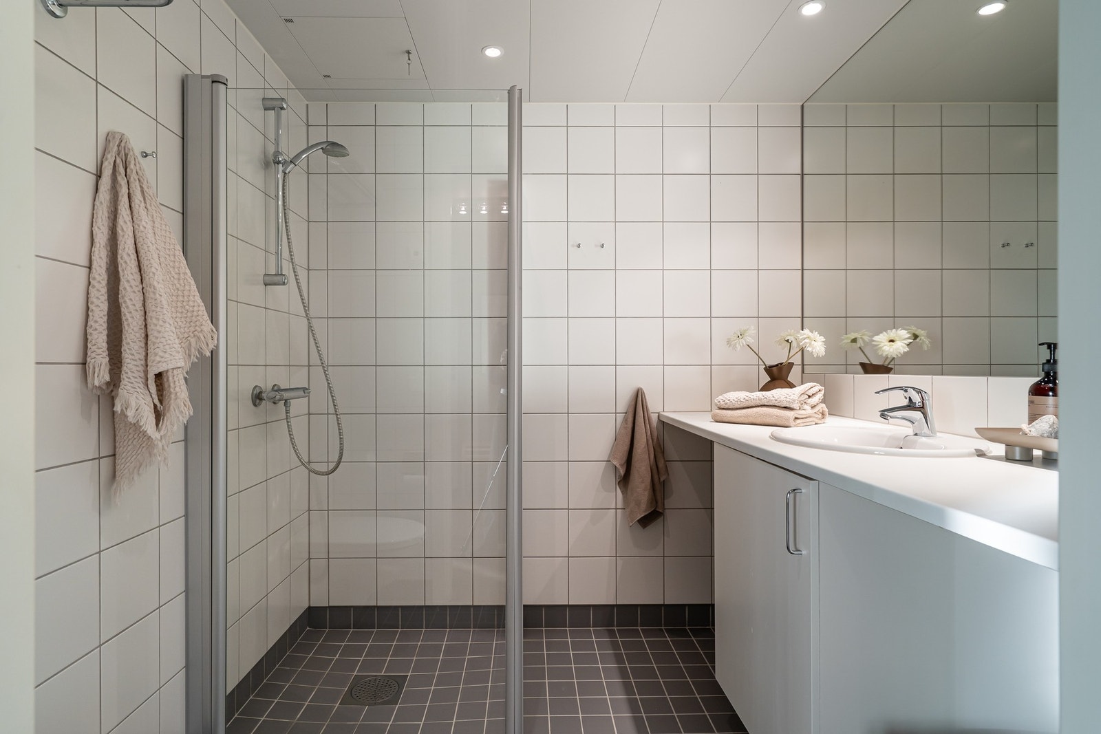 Lyst, flislagt bad med varme i gulv og downlights i himling. Galleribilde