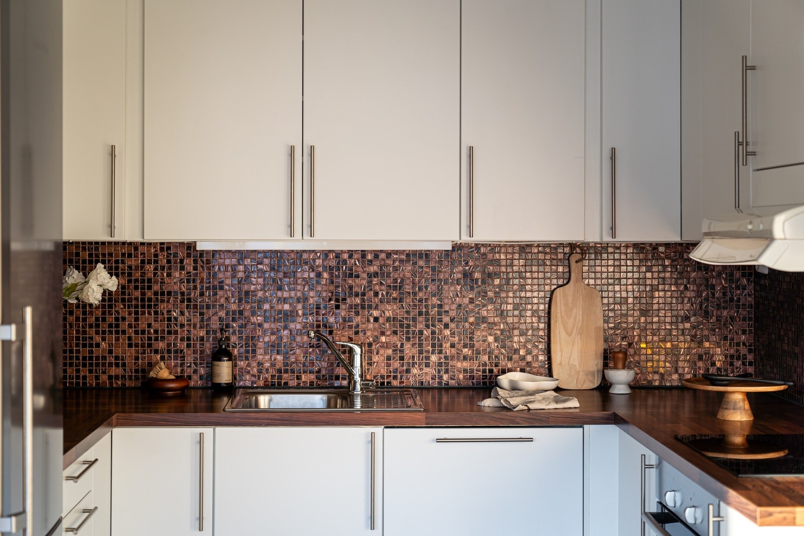 Oppgradert kjøkken fra Augbo Modena med lyse glatte fronter, laminat benkeplate og nedfelt oppvaskkum med ett-greps armatur. Galleribilde