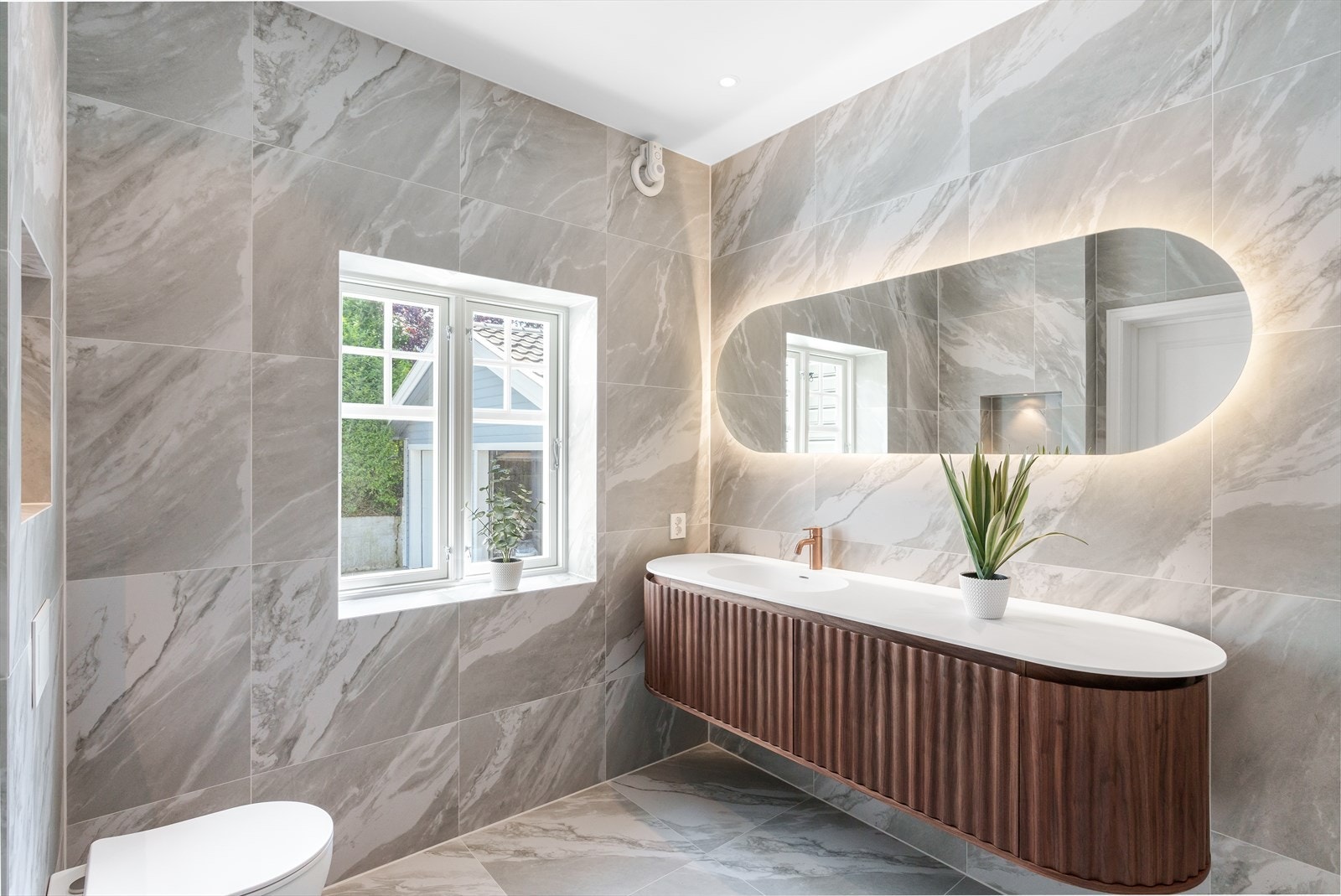 Stort baderom med flott vindu som gir herlig lys. Nydelig flislagt gulv og vegger. Moderne og påkostet baderomsinnredning hvor en har god oppbevaring. Galleribilde