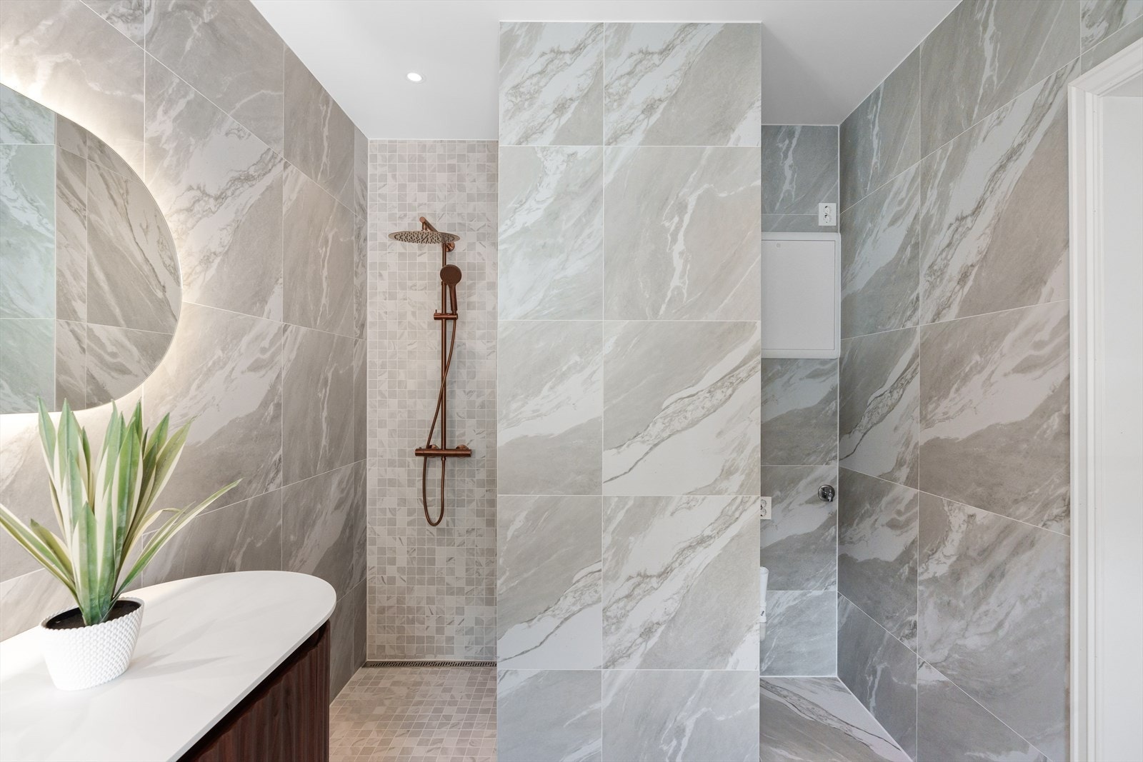 Flott dusjnisje og egen nisje til vaskemaskin og tørketrommel. Vegghengt wc. Galleribilde