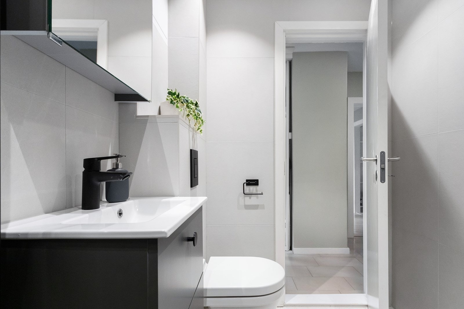 Badet har varmekabler i gulv, opplegg for vaskemaskin, servant med oppbevaring, dusjhjørne og toalett Galleribilde