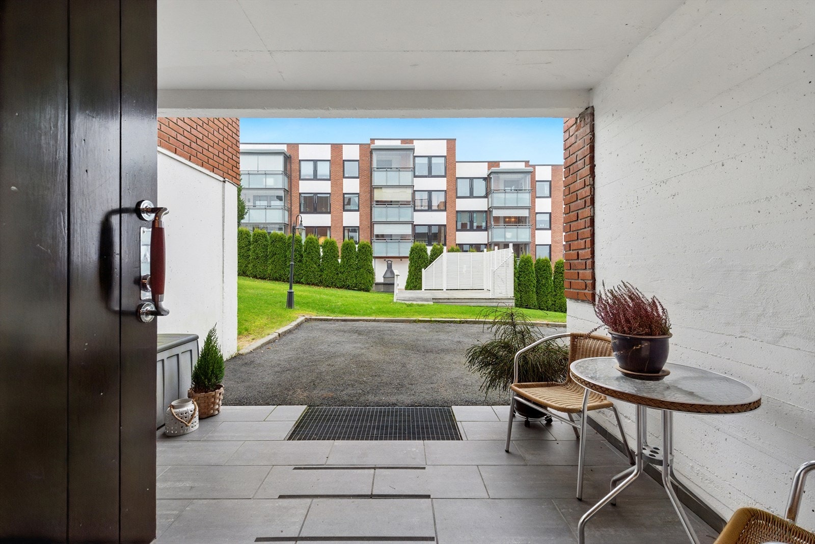 Baksiden av bygget har utgang til en sittegruppe og fellesområdet. Galleribilde