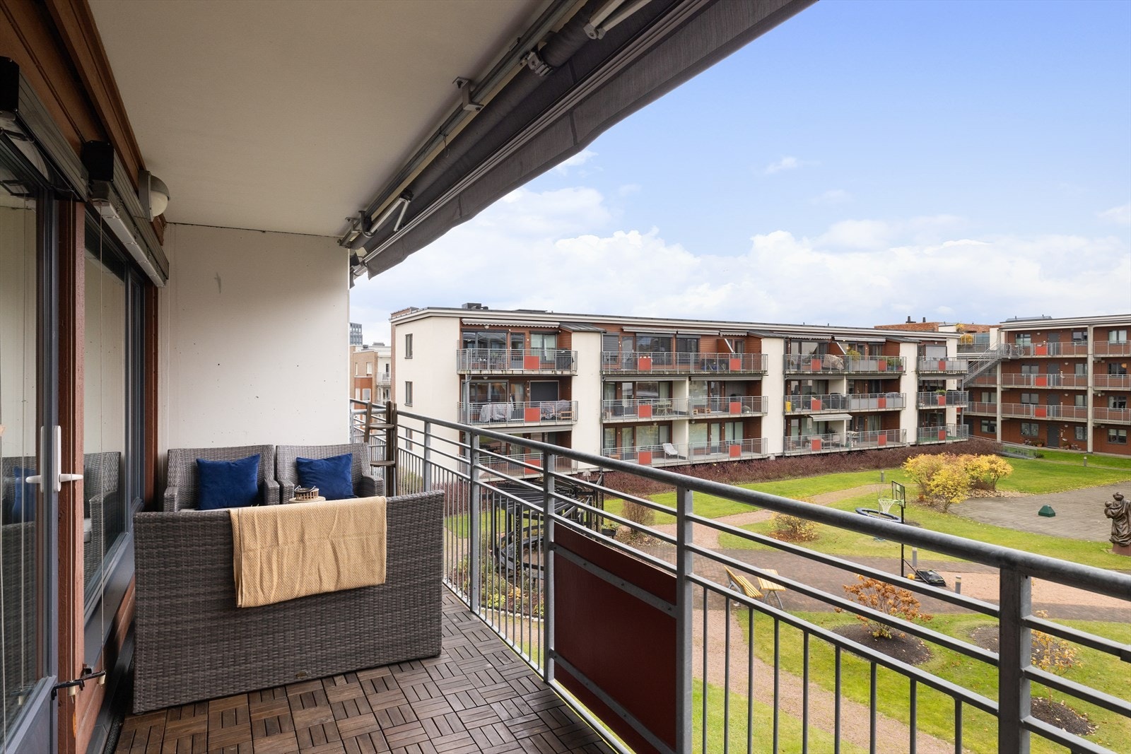 Balkongen er sydvestvendt og ca. 11 m², med trefliser på gulvet og elektrisk markise som gir fleksibel skygge. Galleribilde