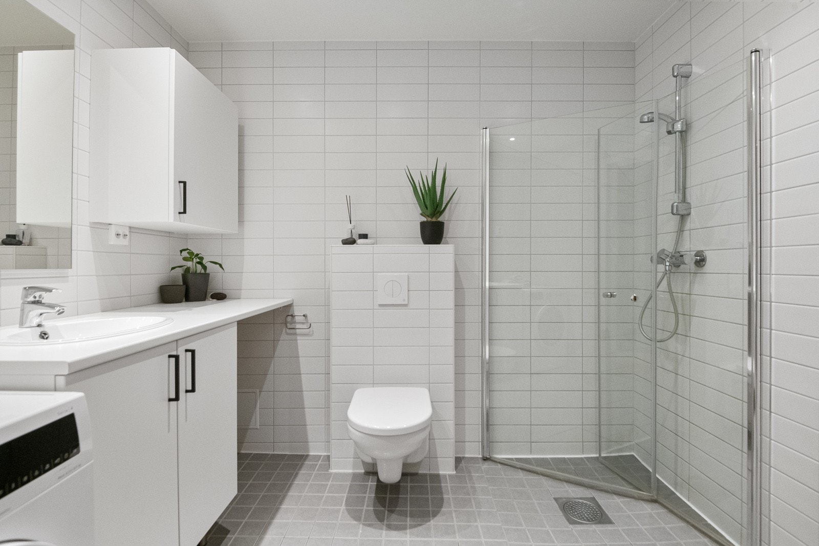 Vegghengt toalett, innfellbare dusjdører, varmekabler i gulv og downlights i taket med dimmer. Galleribilde