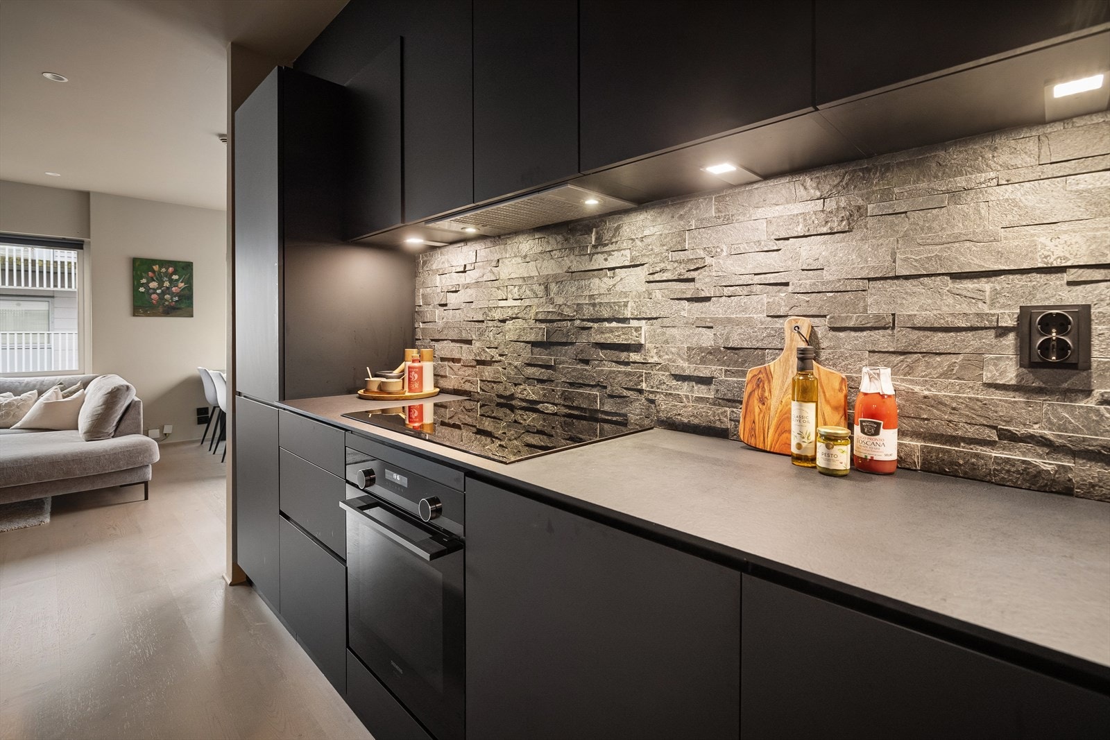 Moderne, smakfullt kjøkken fra Kvik. Tidsriktig innredning fra 2020 med glatte fronter, skifer på vegg over kjøkkenbenk og benkeplate i laminat. Galleribilde