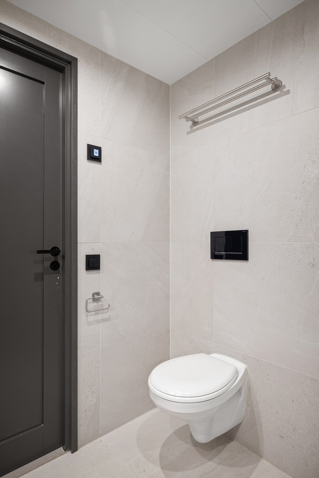 Rommet består av veggmontert toalett, dusjhjørne med innfellbare glassdører og baderomsinnredning med bolleservant, ettgreps blandebatteri, skap og speil. Galleribilde