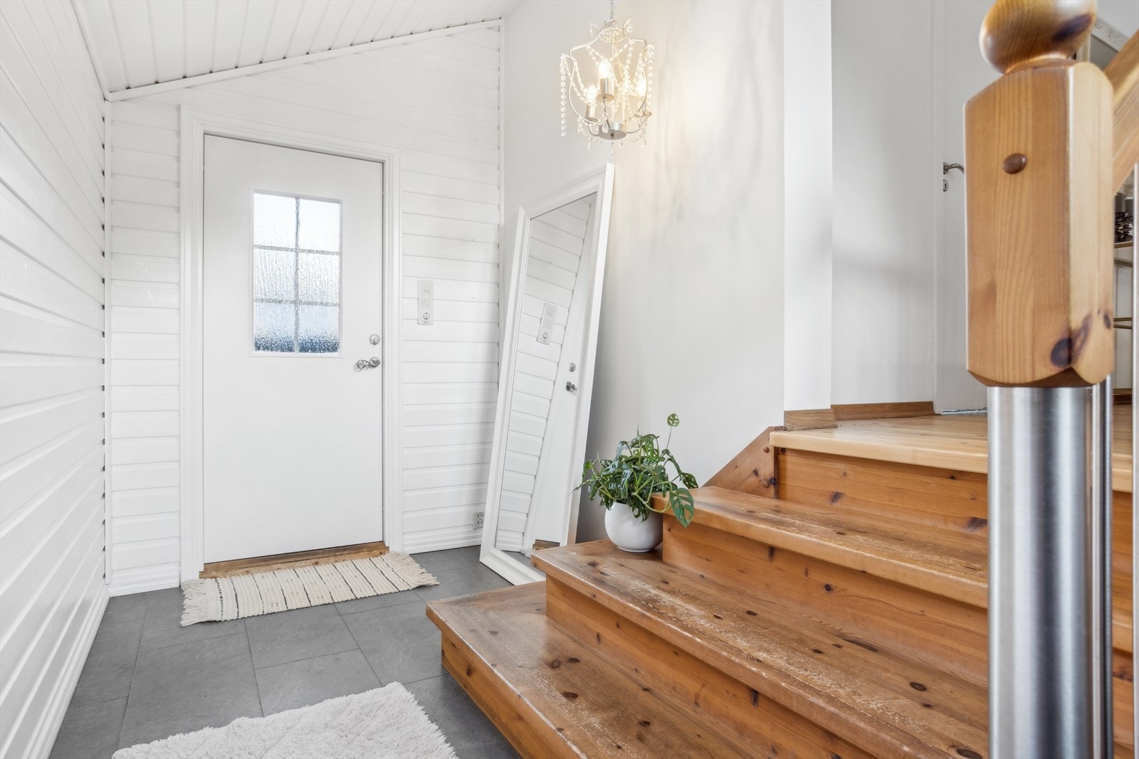 Romlig og lys entré med flislagt gulv. Galleribilde