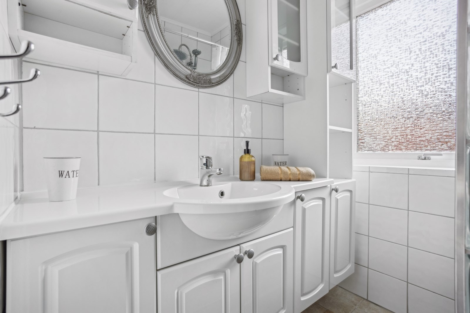 Bad i første etasje med fliser på gulv og vegger. Himling av malte plater. Det er varme i gulv, dusjhjørne og toalett. Galleribilde