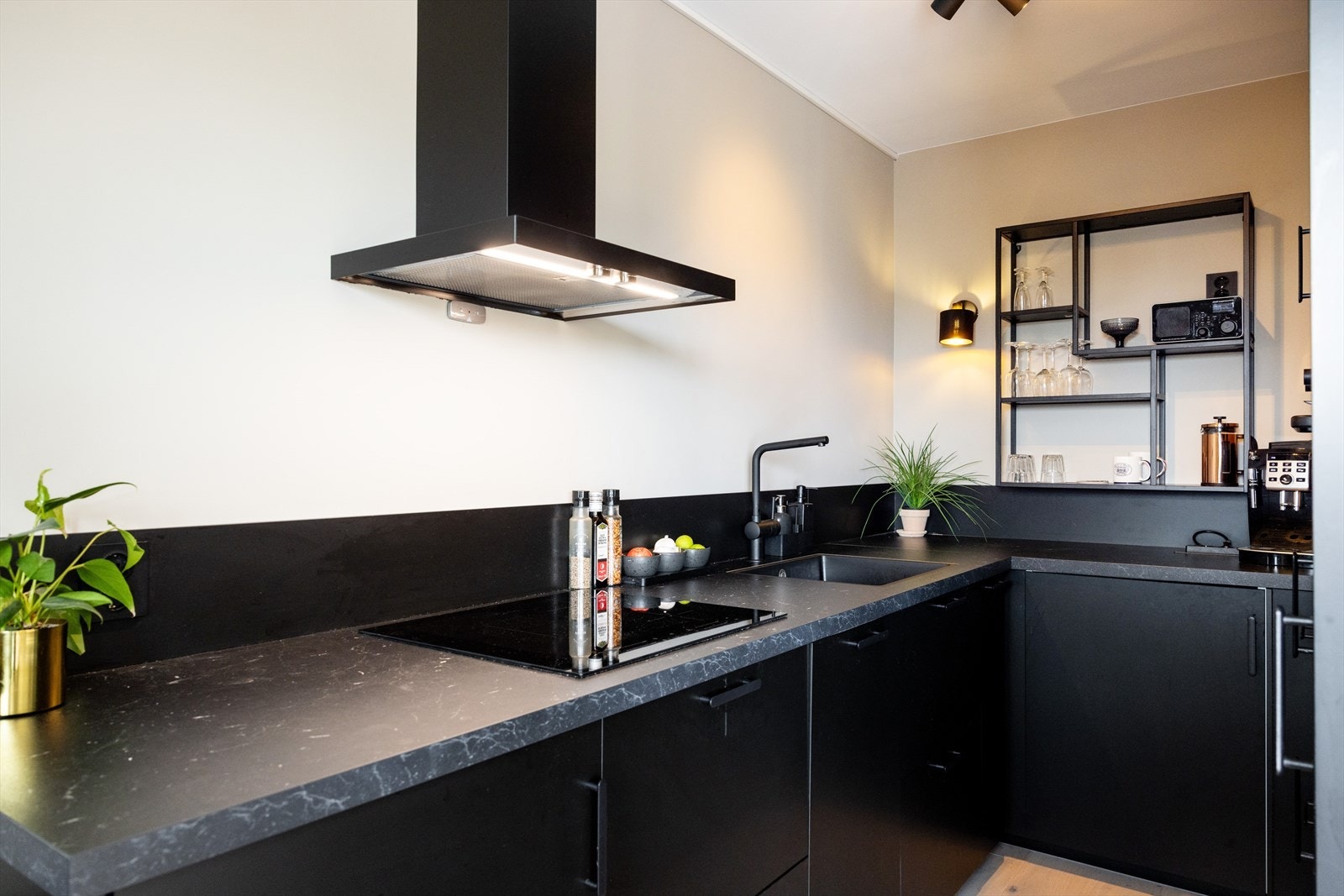 Kjøkkeninnredningen består av sorte glatte fronter og benkeplate av laminat med planlimt vask- og skyllekum. Opplegg for vaskemaskin under benkeplate. Galleribilde