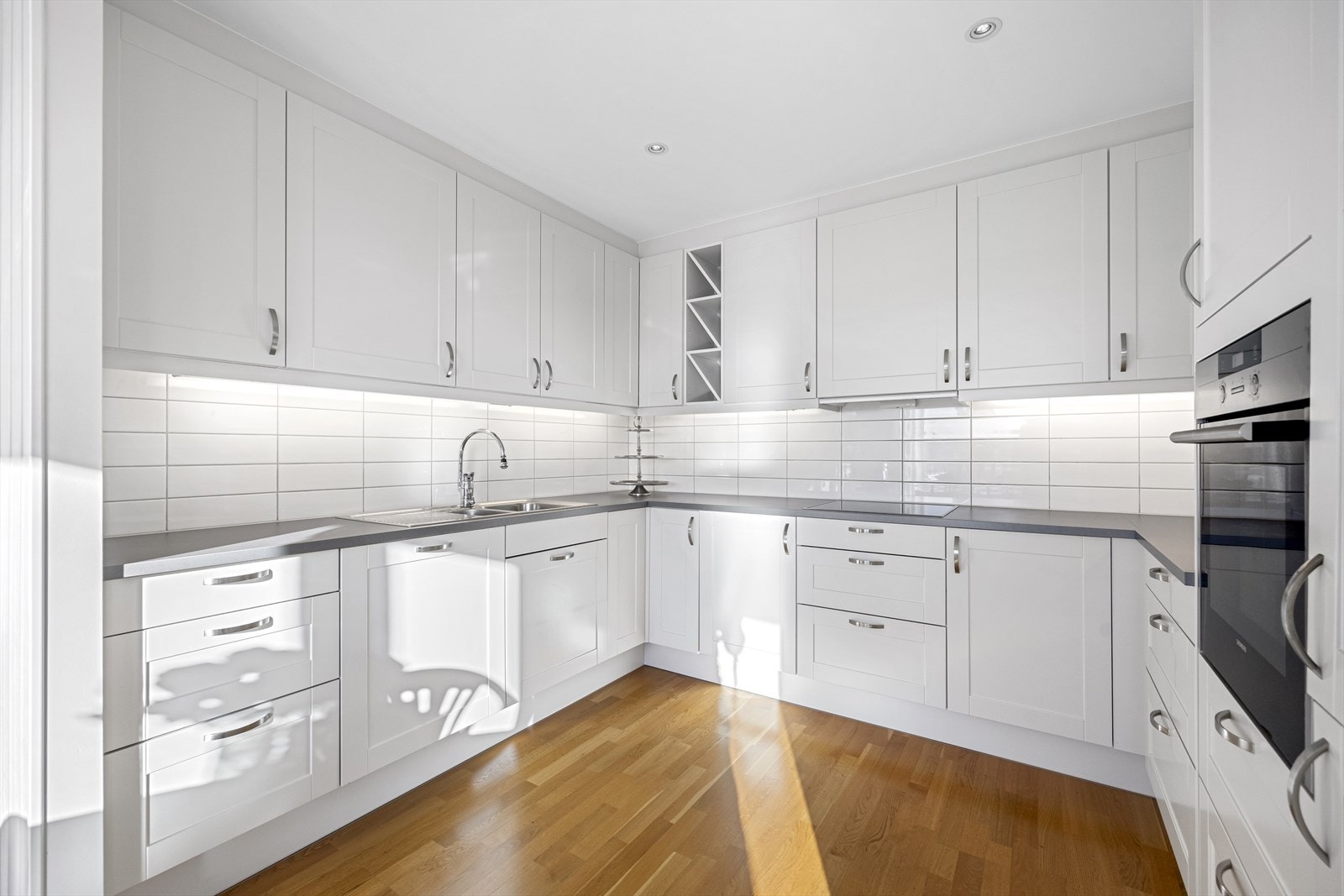 Kjøkkenet har innholdsrik innredning fra HTH i hvit, profilert utførelse Galleribilde