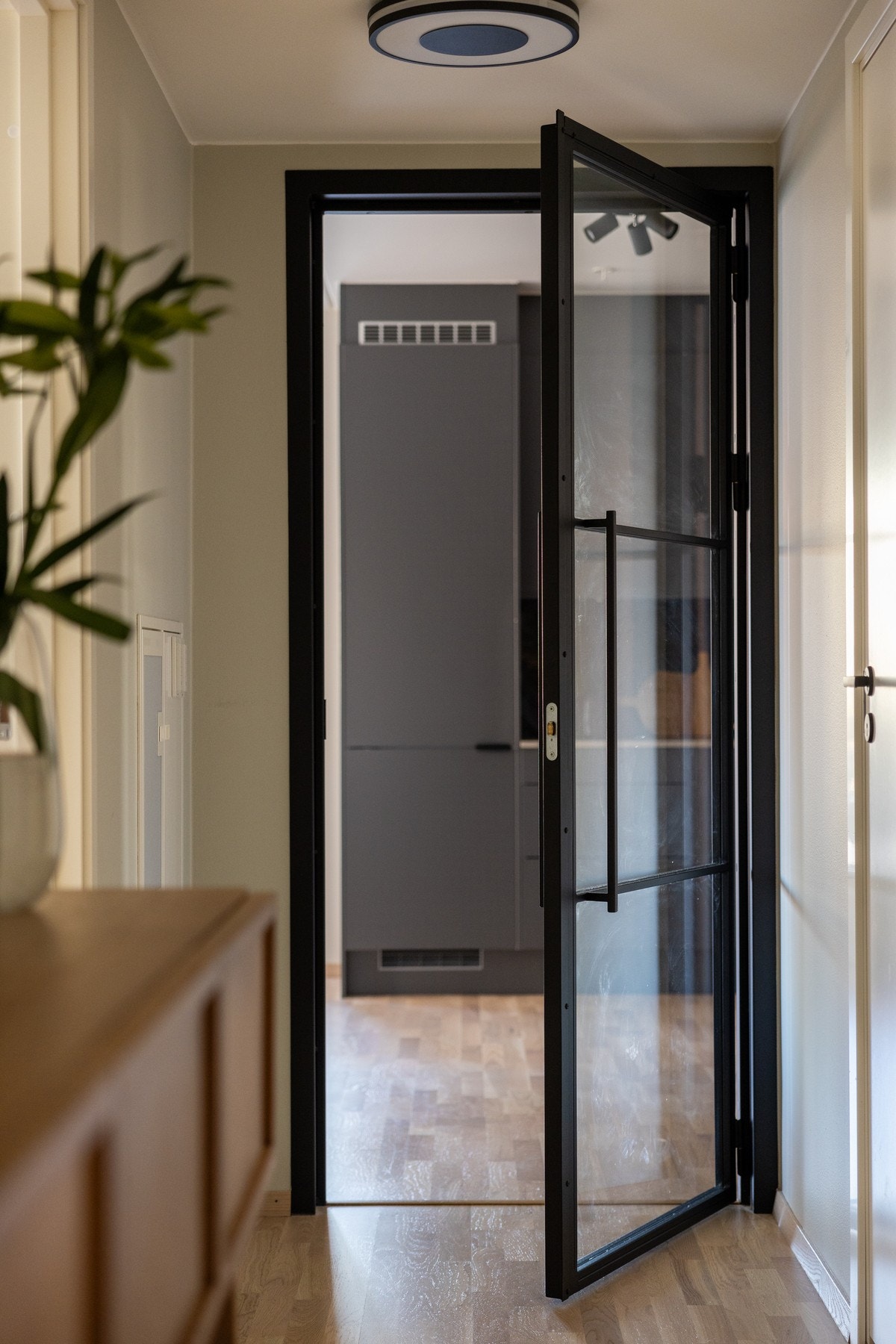 En nydelig smijernsdør med glassfelter og god lydisolering mellom stuen og entreen hvor det blant annet er adkomst til to av soverommene Galleribilde