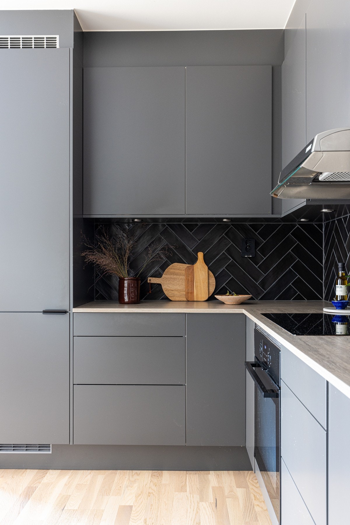 Kjøkkenet fremstår stilrent og gjennomført og byr videre på praktiske egenskaper som mye benkeplass og oppbevaringsplass Galleribilde