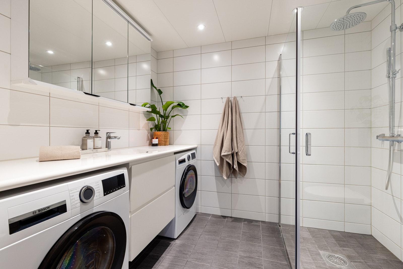 Badet er tidløst innredet med lyse fliser og innredning Galleribilde