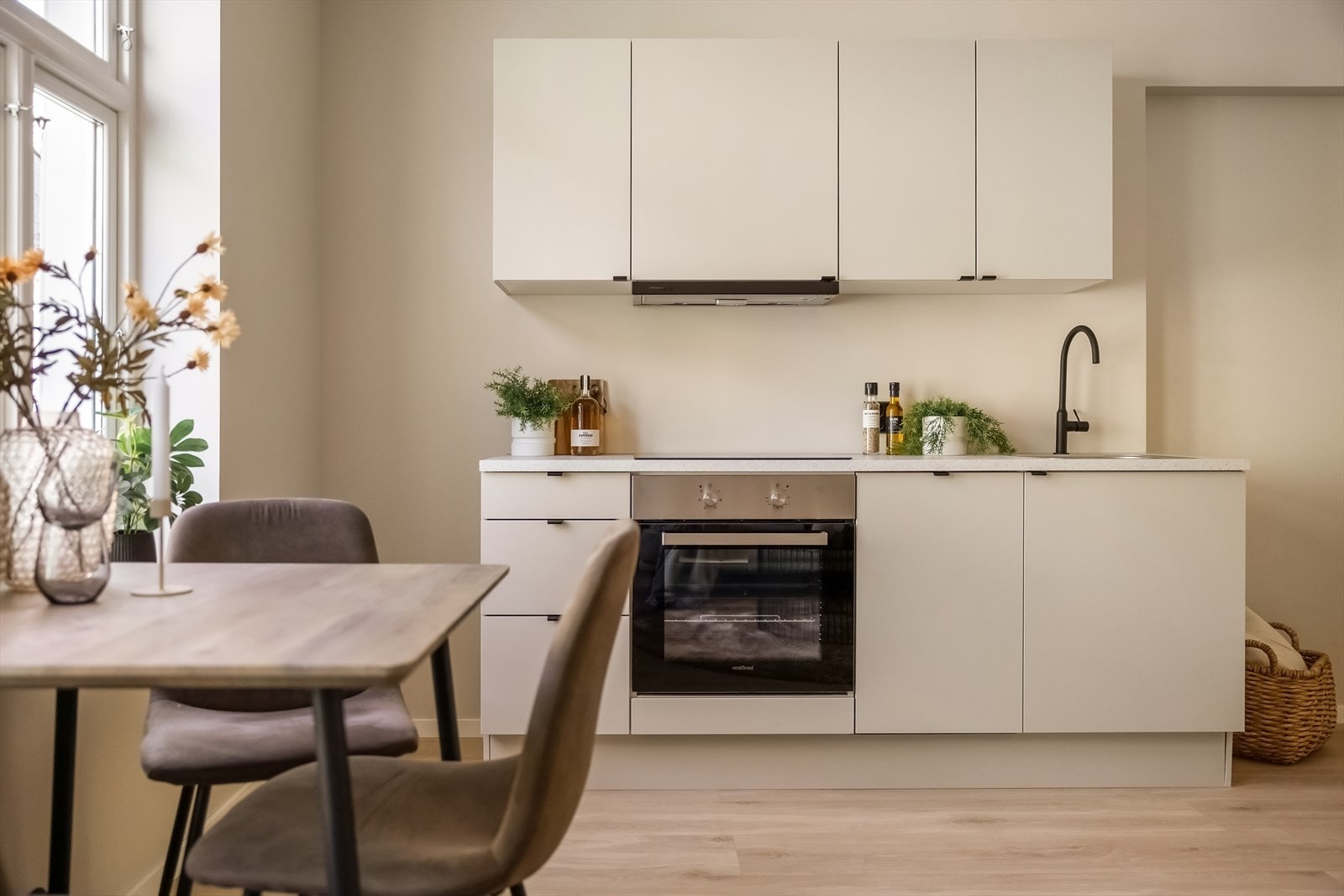 Kjøkkenet har godt med både skap- og benkeplass og inneholder innredning med slette fronter, laminat benkeplate, stål oppvaskkum og ventilator Galleribilde